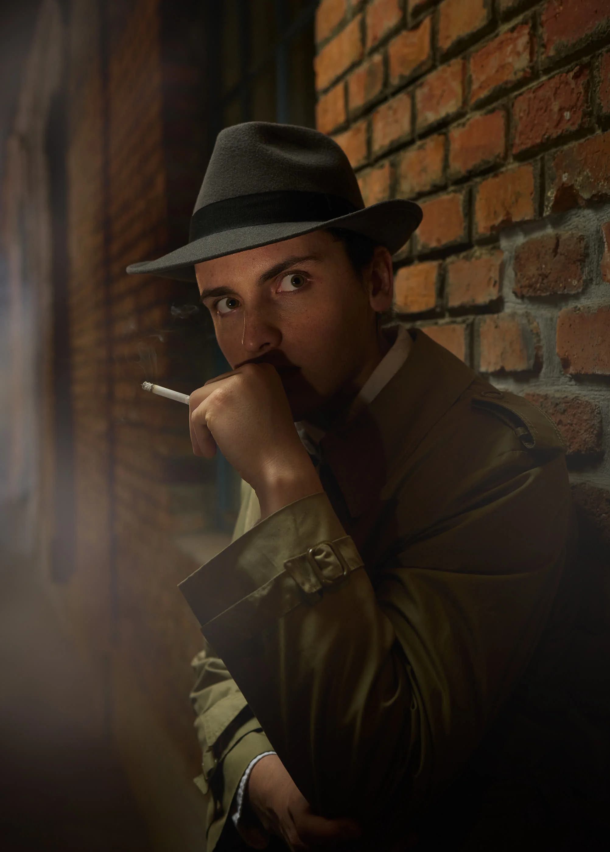 A man with a hat and a cigarette looking mysterious