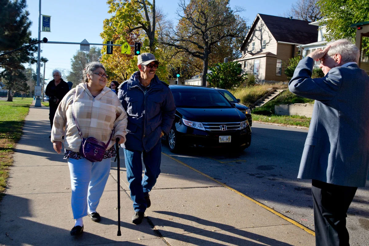 Photo of Amelia and Pedro Cruz walking to their polling place in November 2016 with Warren Buffet by Sarah Hoffman/The World-Herald