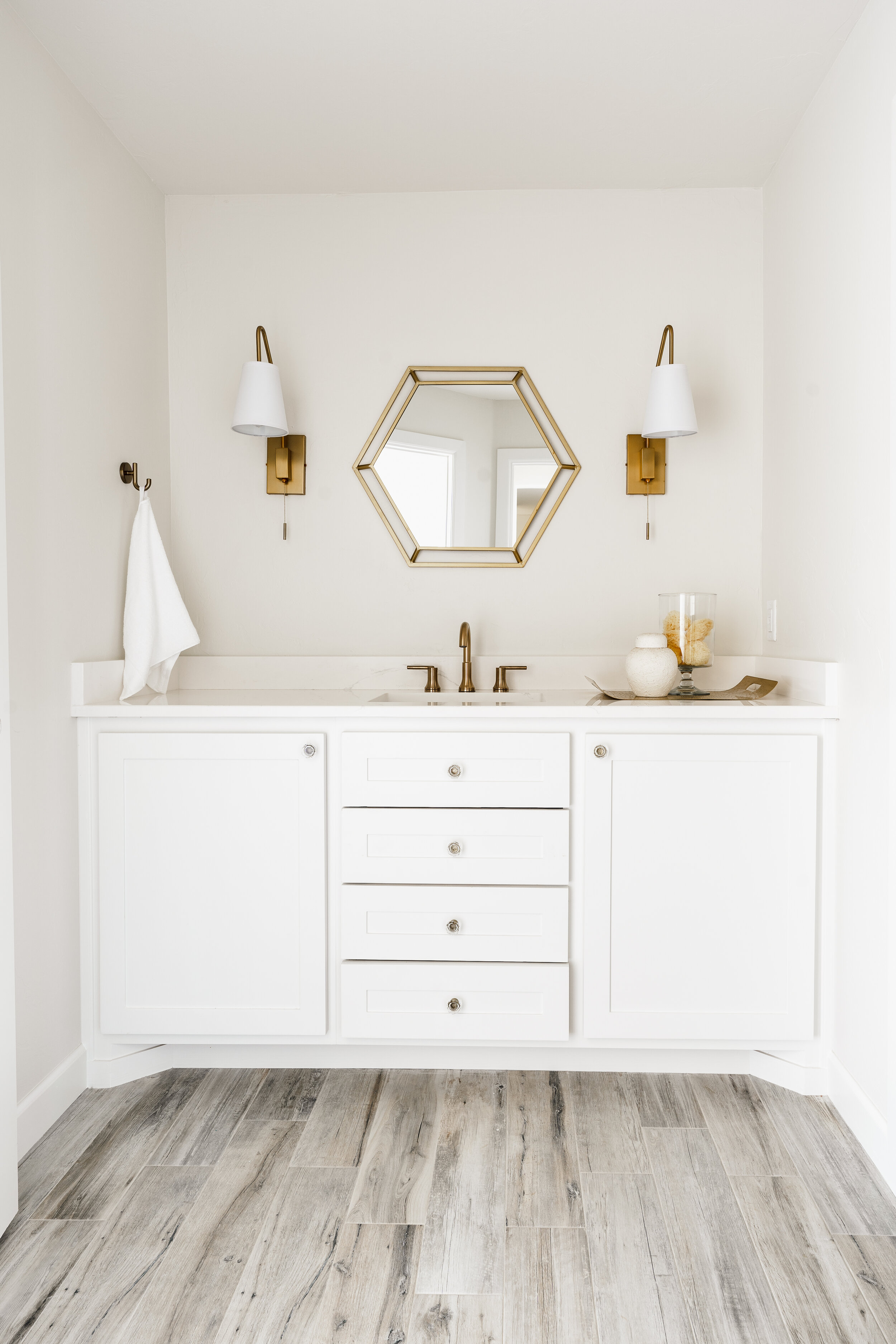 White bathroom vanity with gold mirror