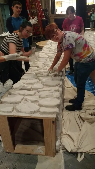  I led a crew of peers to cover each stone with a layer of goop (joint compound, painters caulk and water.) 