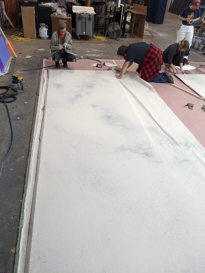  Stapling fabric to the back of steel frames. 