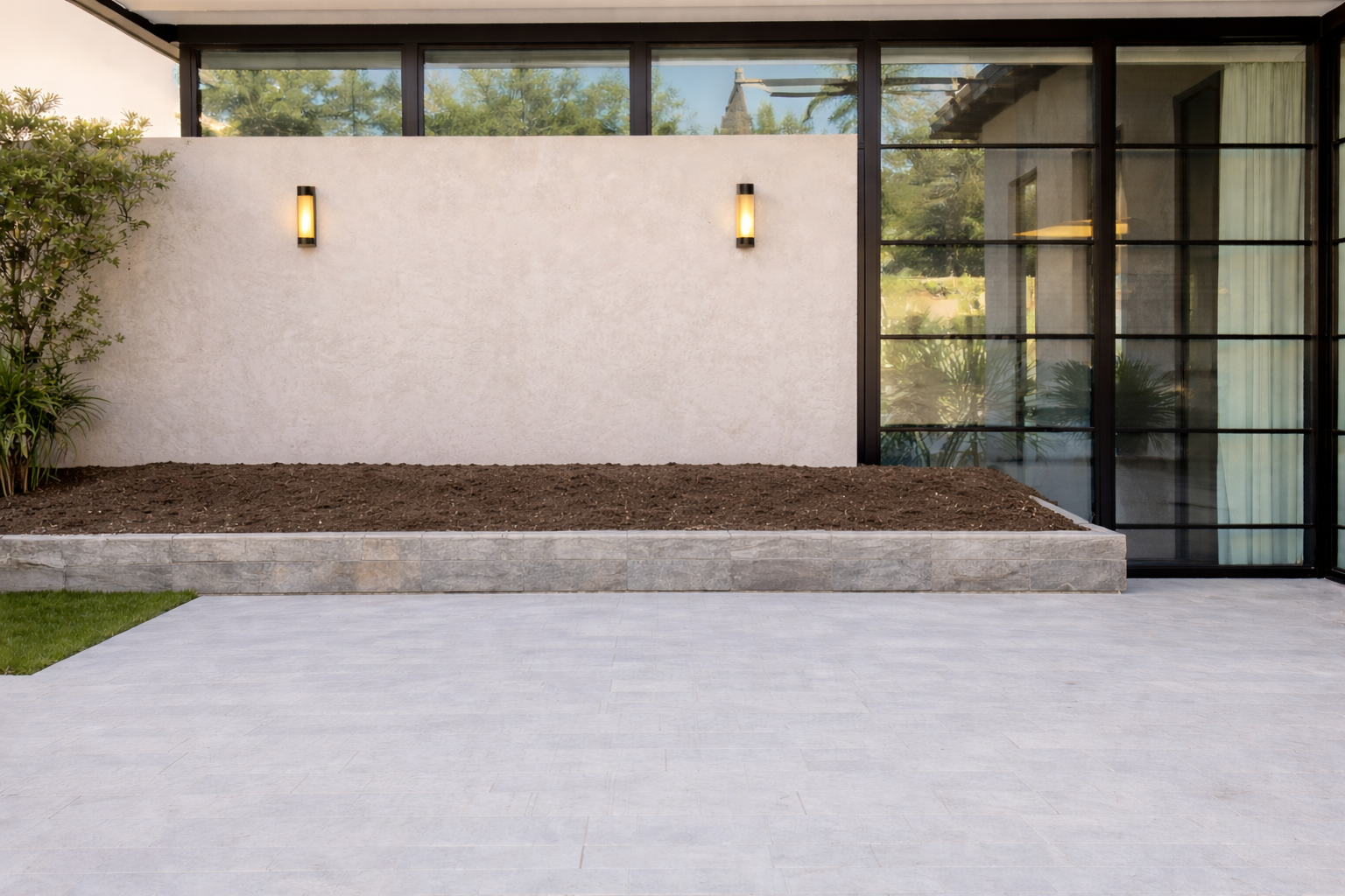 A modern patio with a privacy wall, planter and wall sconces