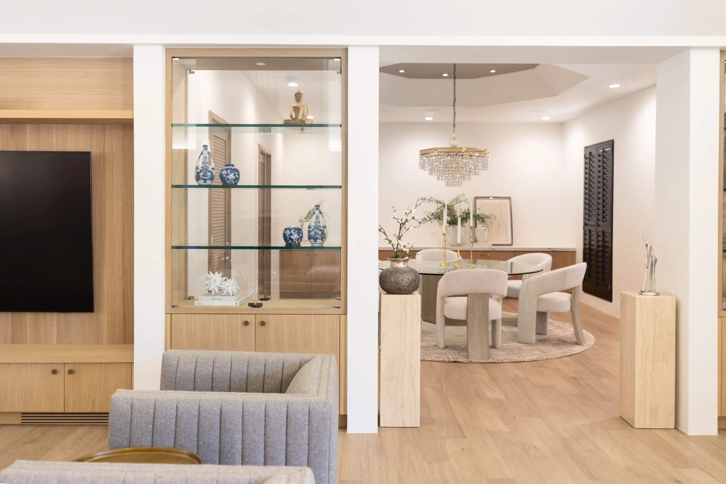 Open interior connecting the living and dining spaces with warm wood flooring and custom millwork