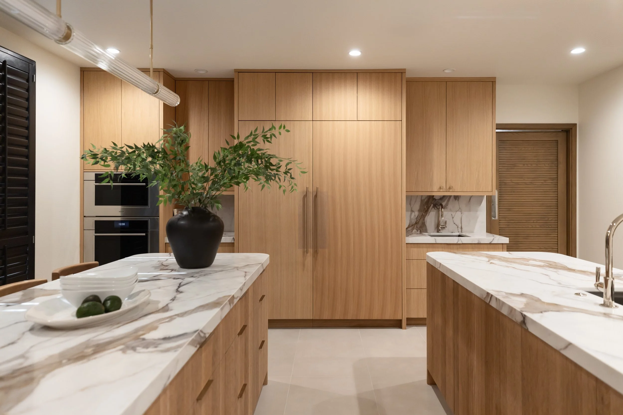 Kitchen with warm white oak, stone countertops, cement floor