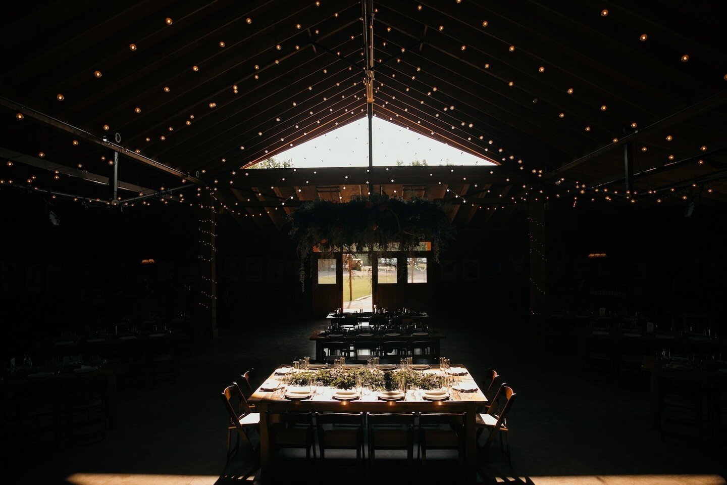 A head table awaits its big moment.⁠
&mdash;&mdash;&mdash;&mdash;&mdash;&mdash;&mdash;&mdash;⁠
mic drop by @cassierosch⁠
&mdash;&mdash;&mdash;&mdash;&mdash;&mdash;&mdash;&mdash;⁠
Planning + Design @rootandgatherevents⁠
&mdash;⁠
Venue @planet.bluegras