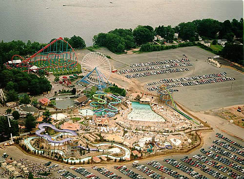  Here is a view of the section of Six Flags New England where the large ferris wheel and the water park, Hurricane Harbor,reside. It must have been a pretty warm day, given all the people in the tidal pool. In the background are boats zipping by on t