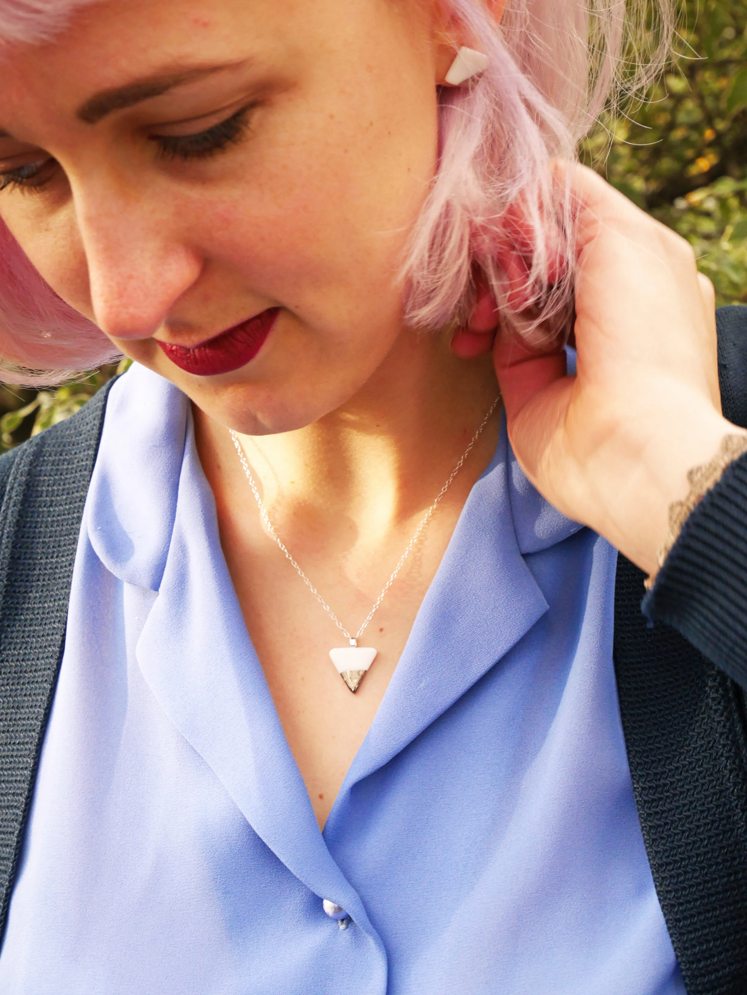 Model with lilac hair wearing porcelain pendant with platinum lustre
