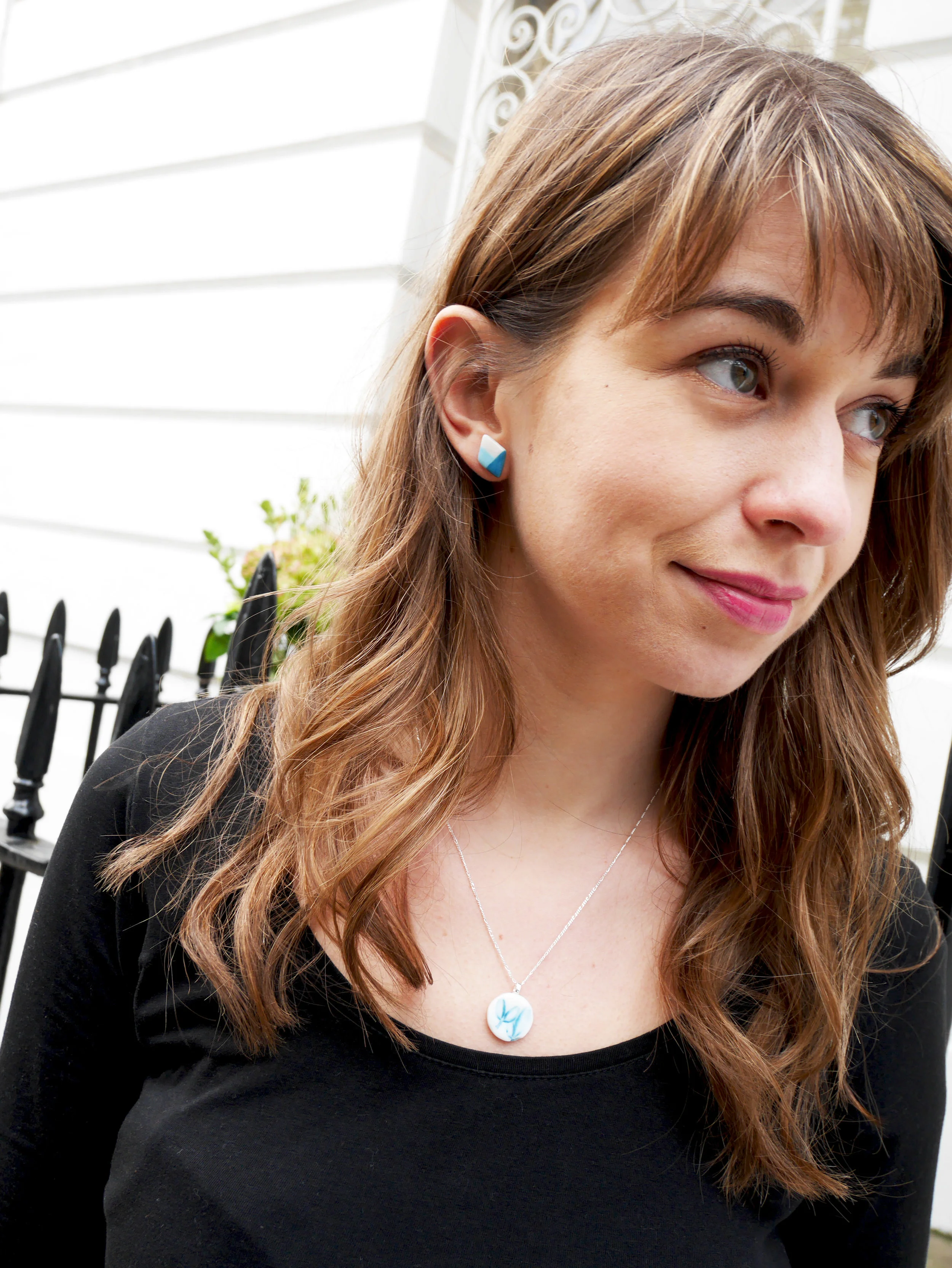 Brunette model wearing ceramic earrings and pendant