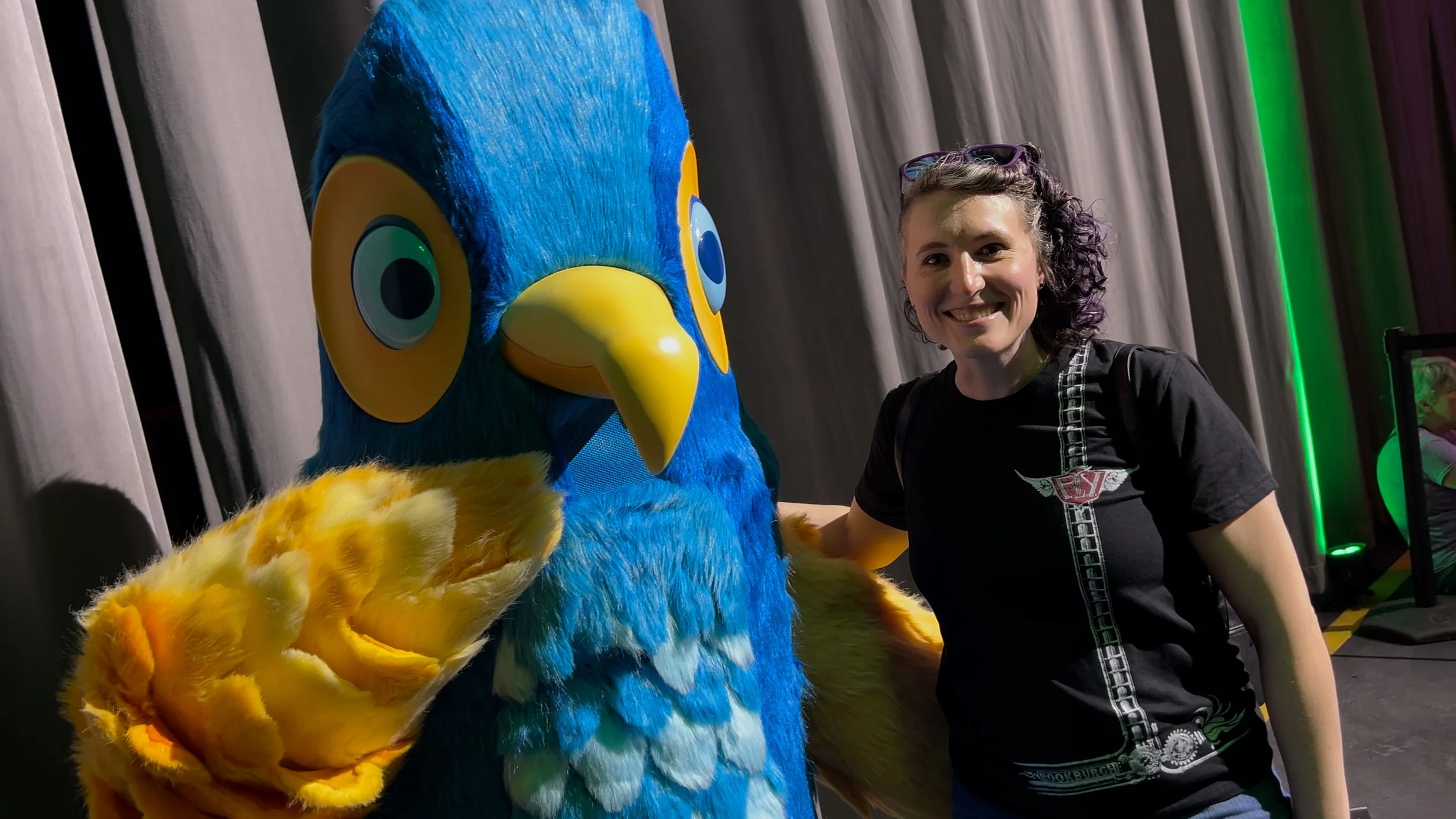 Katie poses for a photo with Churro, the Orlando Informer mascot, during a meet-and-greet at the Arrival Bites area of the 2026 Orlando Informer Meetup.