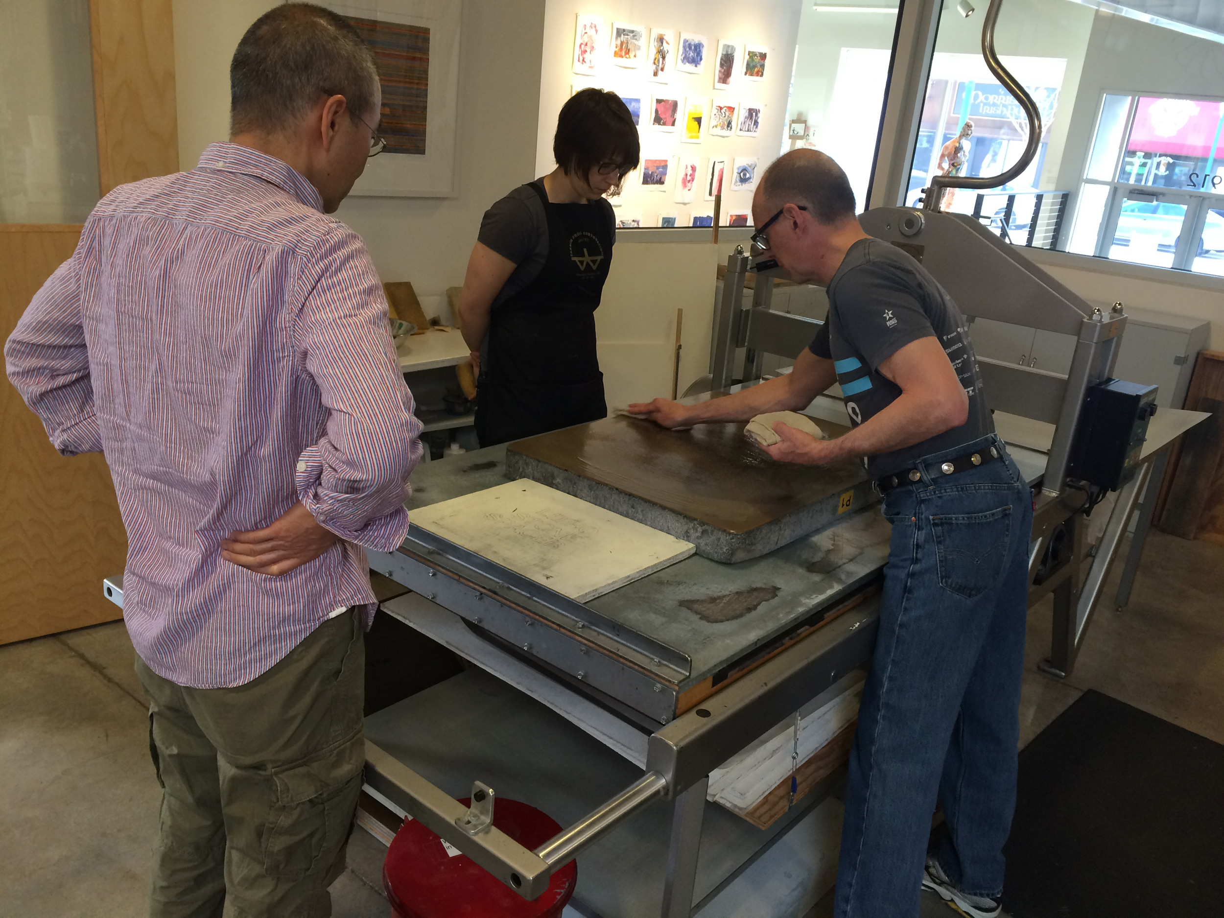 HPE Artist, Do Ho Suh, observing the printing of his stone lithograph