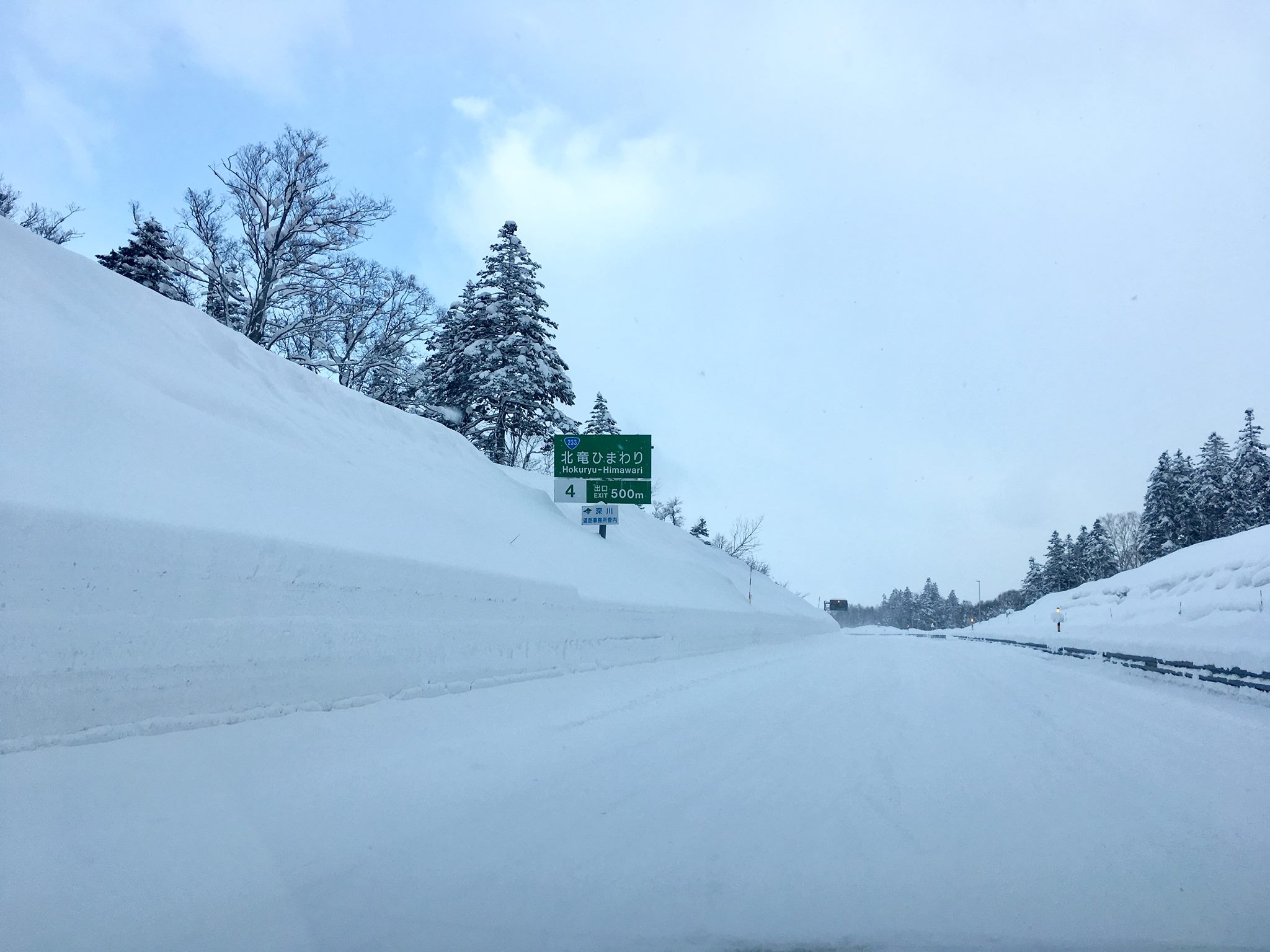 Huge snow banks along the highway and no asphalt to be seen.