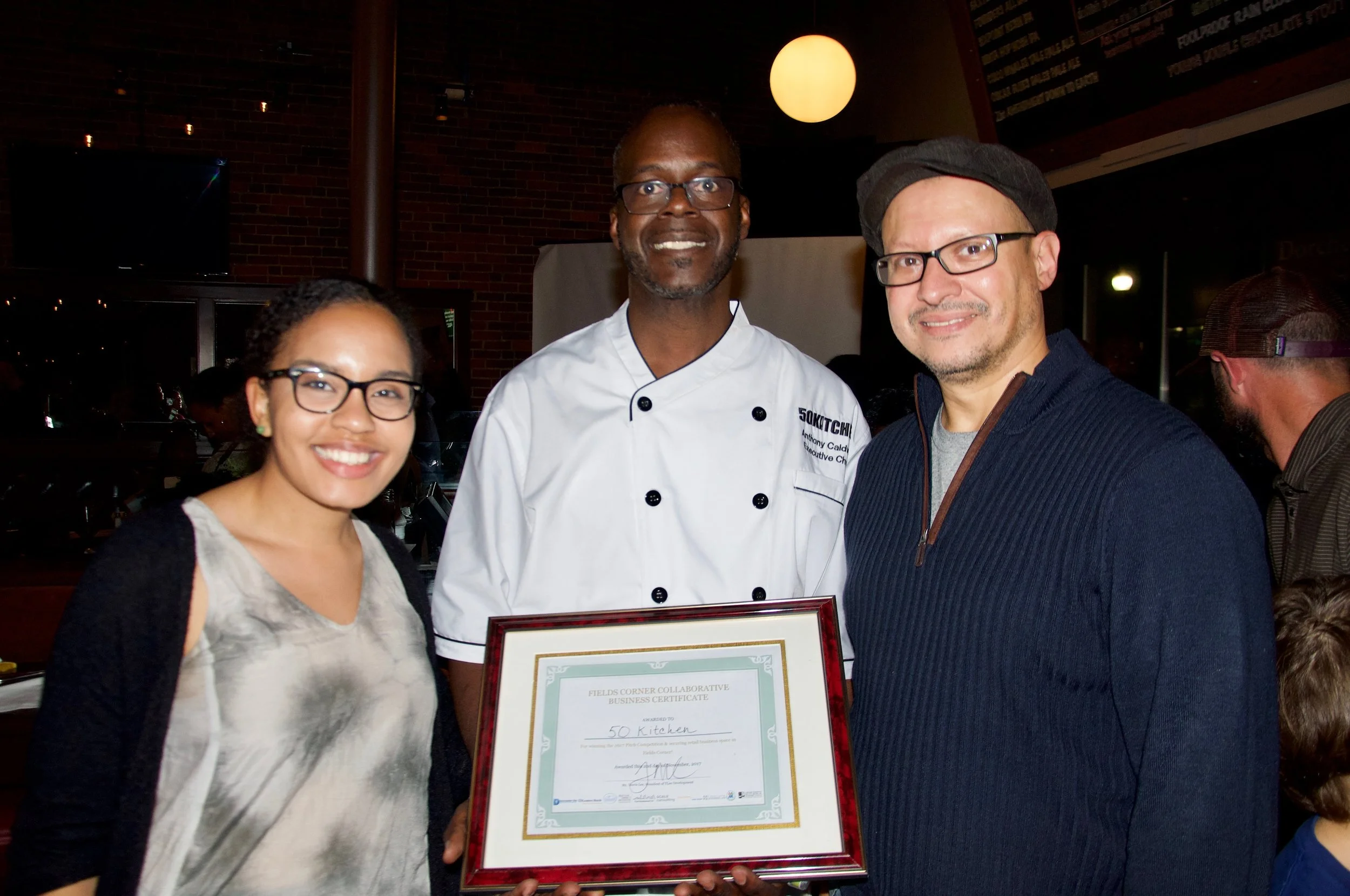 Anthony Caldwell (middle) celebrates with Strategy & Development Director Amine Benali and QVS Fellow Shaina Robinson (Photo by Ben Selden)
