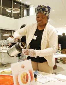 Paulette Ngachoko, Owner of Hapi African Gourmet, pouring Hapi’s signature creamy peanut sauce