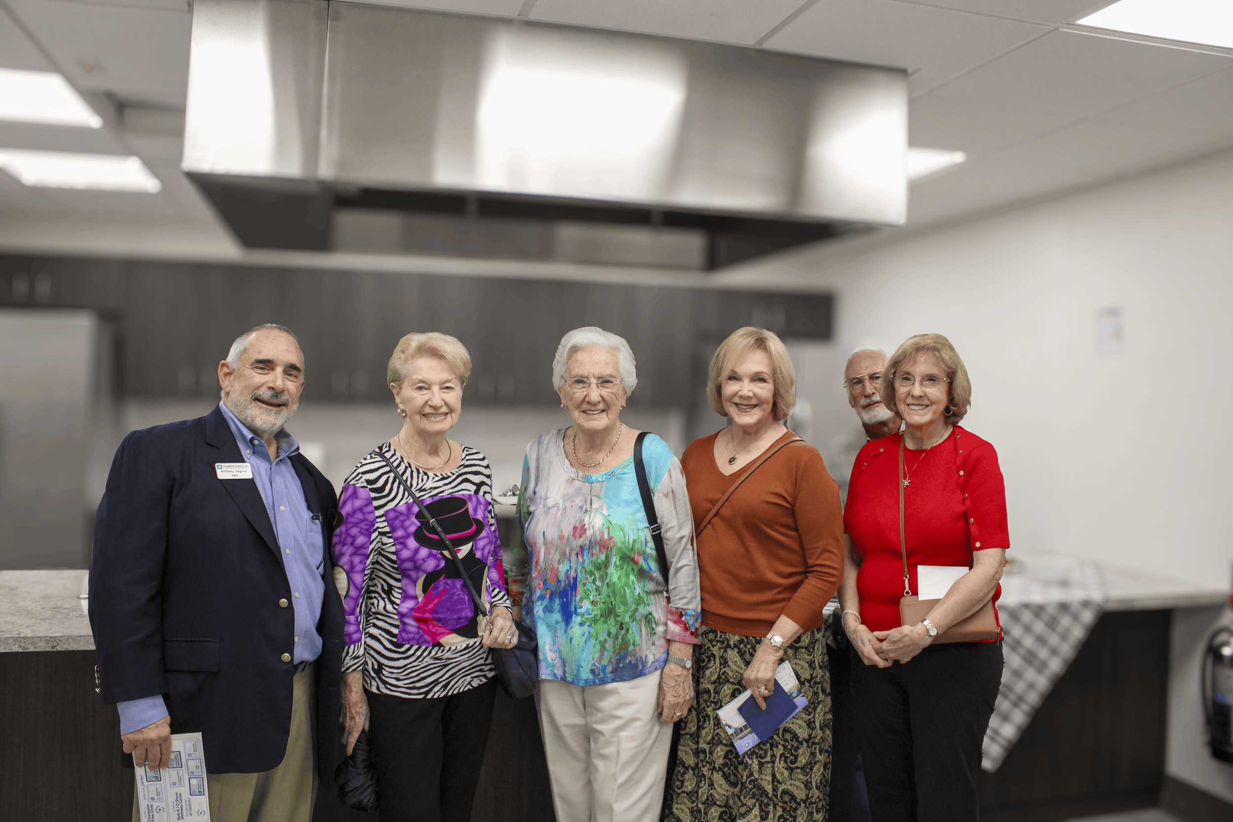Six attendees pose together in the Wellness Center’s Demonstration Kitchen.