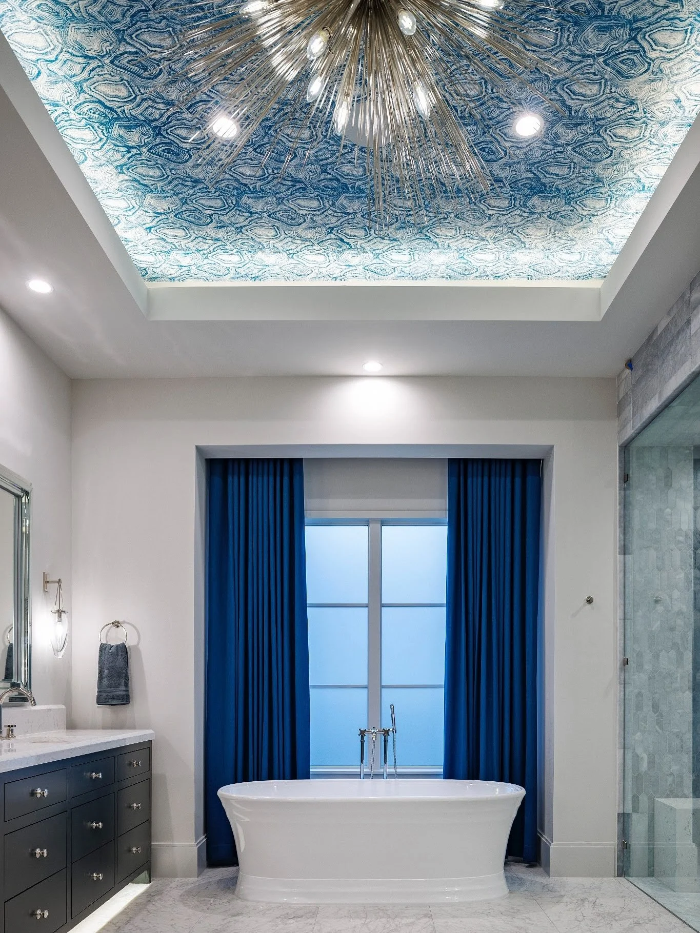 We love a statement ceiling. And isn&rsquo;t this soaking tub in our client&rsquo;s bathroom dreamy? #atxinteriordesign #atxinteriors #bathroomdesign #bathroominspo #kellywearstler #stradachandelier