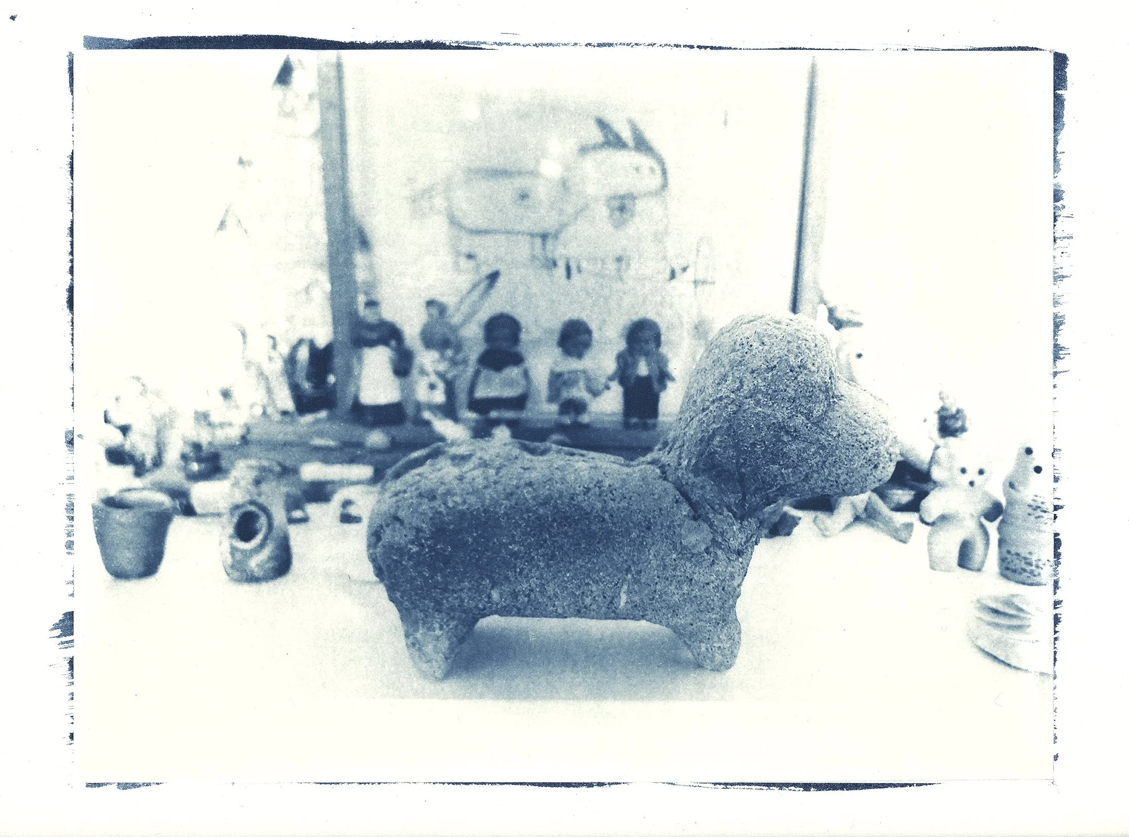 Turquoise cyanotype of objects on an alter - toned with safflower petals. From visual artist Harri Harrison's Grief Commissions