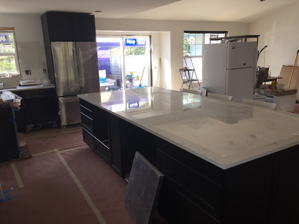 Our Island is 2" short on length and width from a whole slab. I wanted to center the island between the original kitchen and dining room to incorporate the "buffet area" where the previous dining room was. 