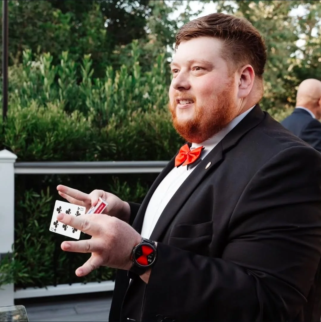 Professional wedding magician performing card flourish at Orange County outdoor ceremony reception