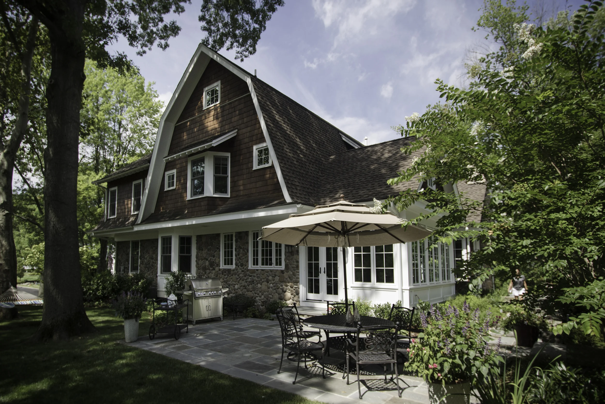 Large trees were maintained on the site. New landscaping was added to create privacy on the corner lot. The patio off the kitchen creates easy access between the kitchen and the grill.