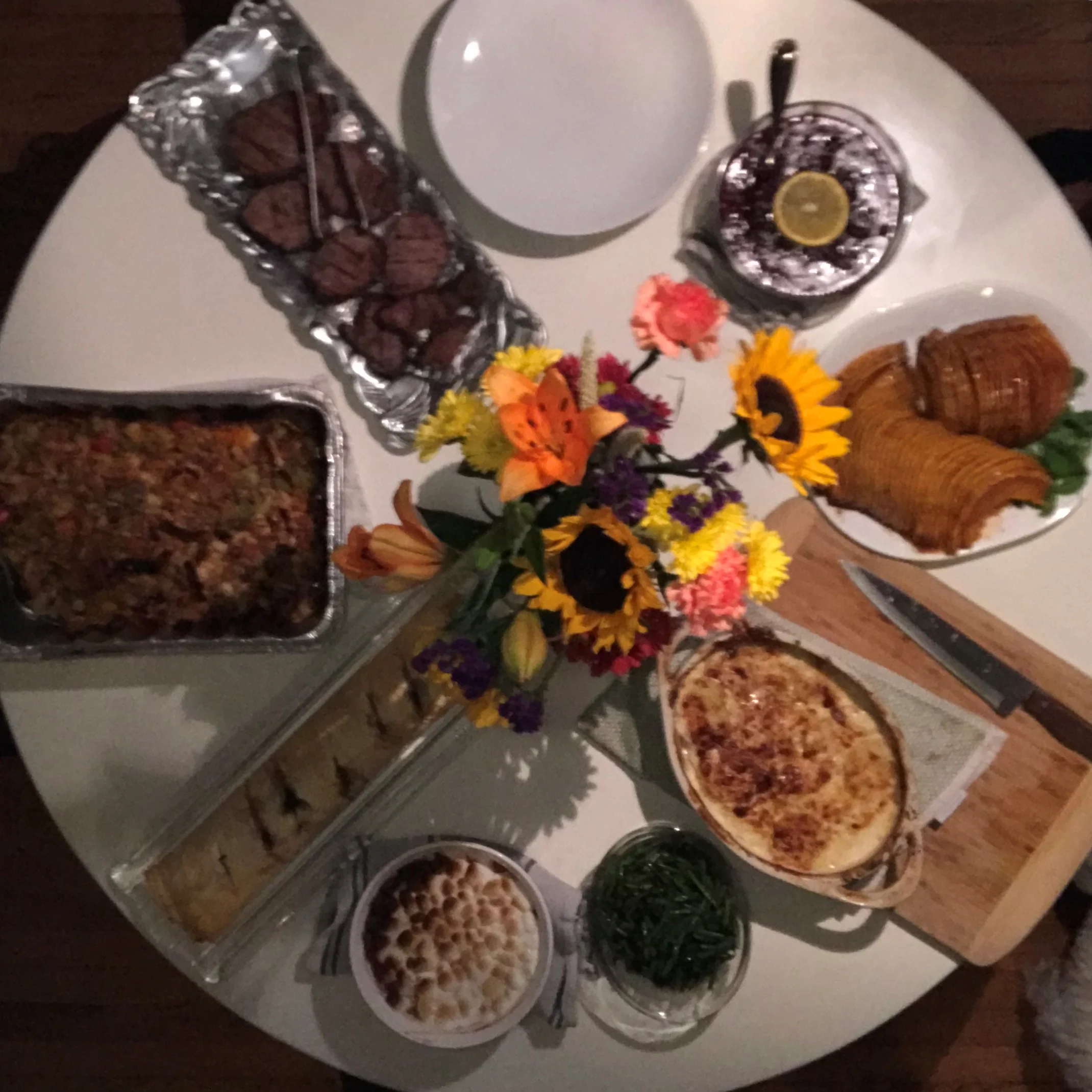 Clockwise from the top Dinner plates, cranberry sauce with extra "sauce", Hasselback squash, scalloped potatoes, green beans, yams Richard, Vegetable Wellington, Oyster Dressing and Grilled Steak. 
