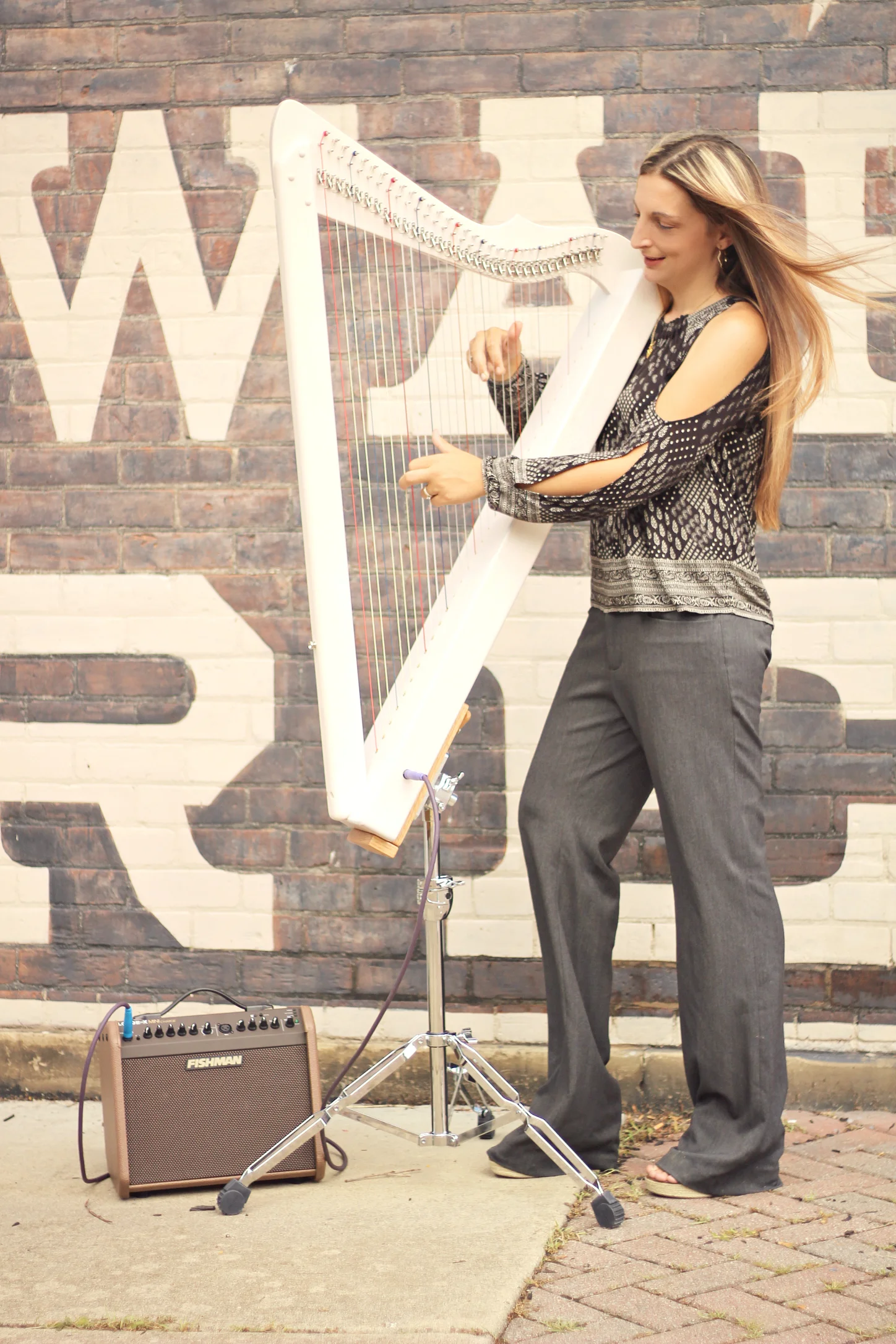 Ashley with a Grand Harpsicle® Harp in the Grand Standing Stand. She also is using the Fishman Loudbox Mini Charge Amp and an Asterope Hi Def Cable.