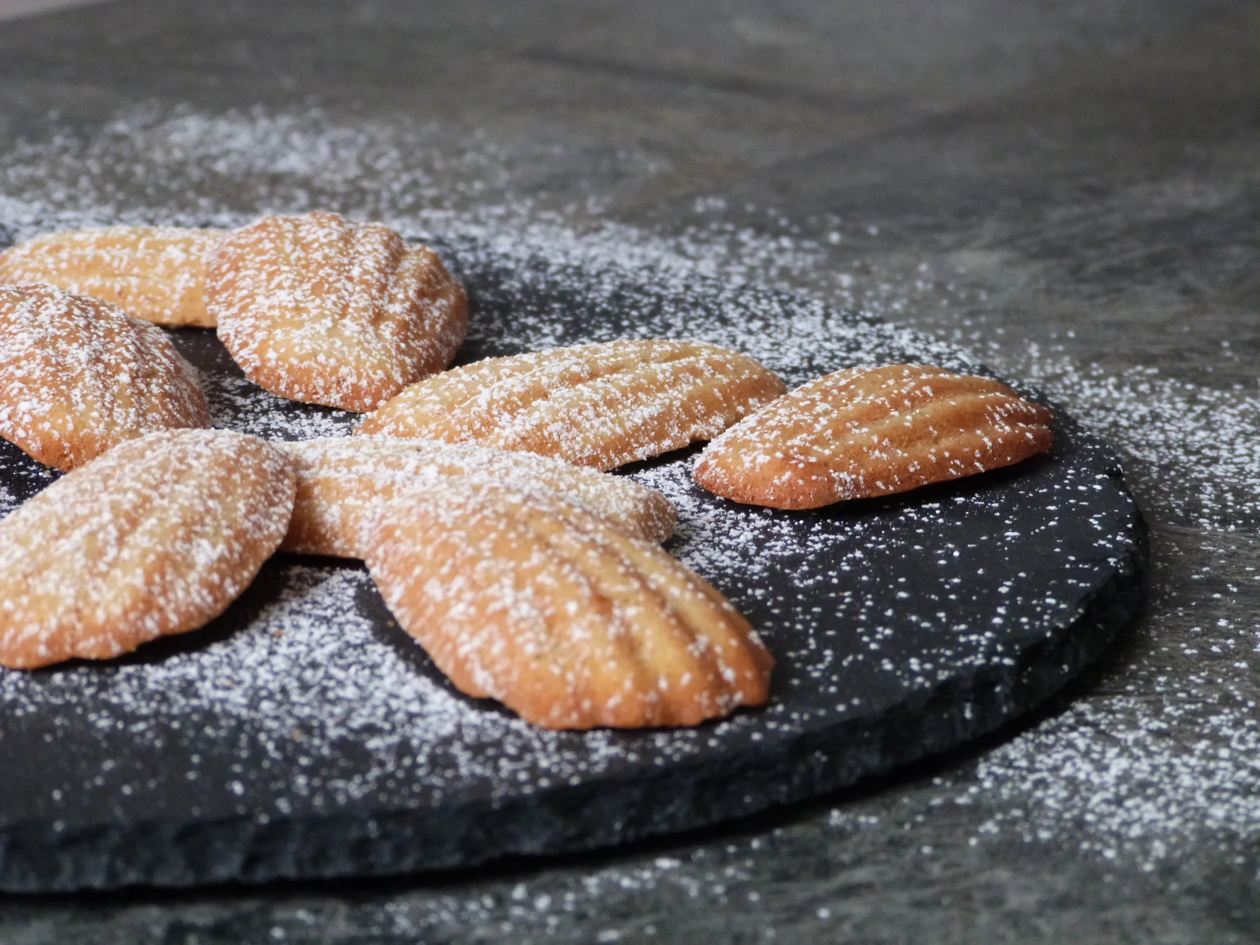 Madeleines dusted with powdered sugar.webp