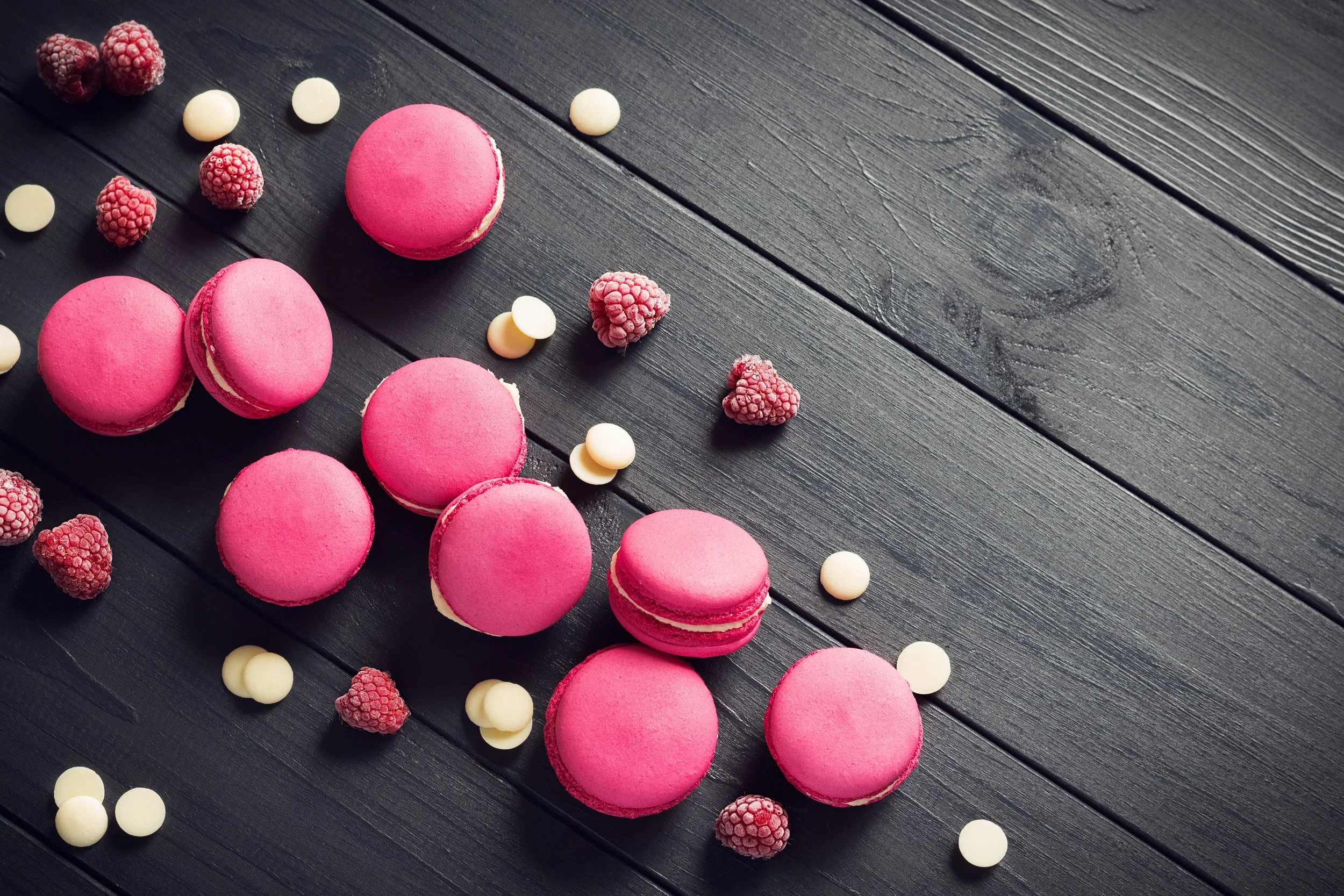 Pink macarons with raspberries and white chocolate chips.webp