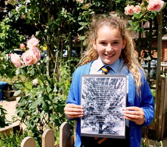 Rebecca Farnfield holding her winning poem