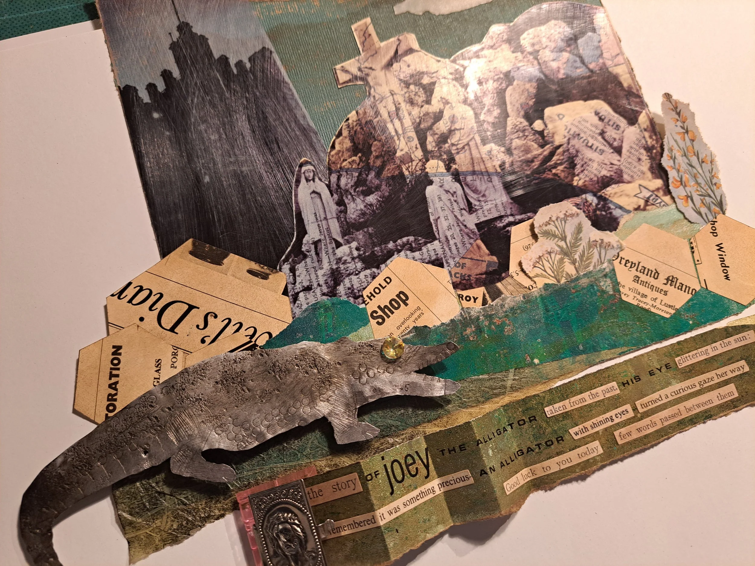 Mixed collage art piece with cut-out images, torn paper, a metal alligator sculpture, and handwritten and printed text elements. Artist assemblage art, illustrating life stories, social history illustration, art in libraries, community artist, 