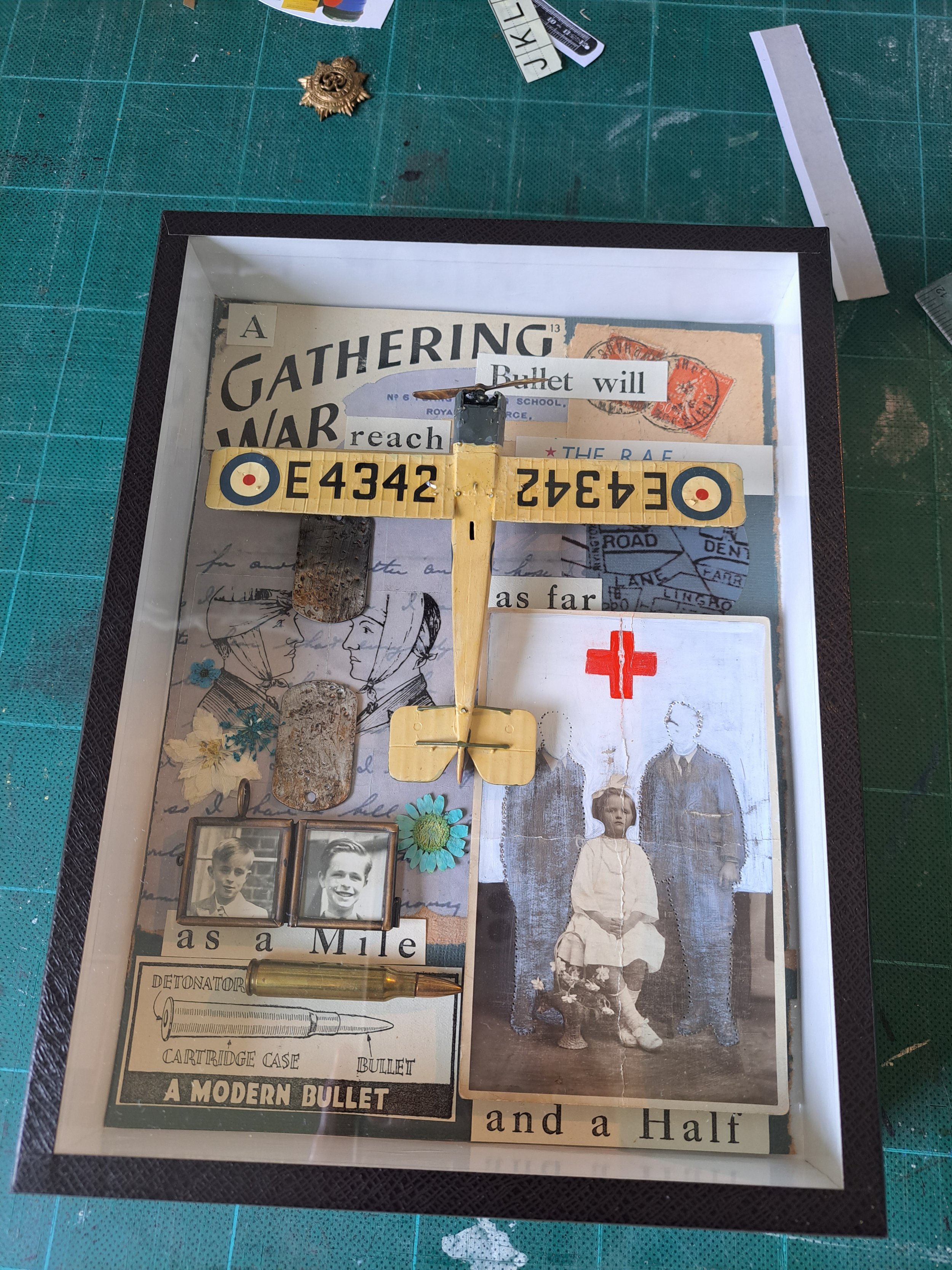 Mixed media collage including vintage photographs, paper clippings, a small vintage airoplane. The collage appears to tell a story related to war, medicine, and personal history. Artist assemblage art, illustrating life stories, social history 