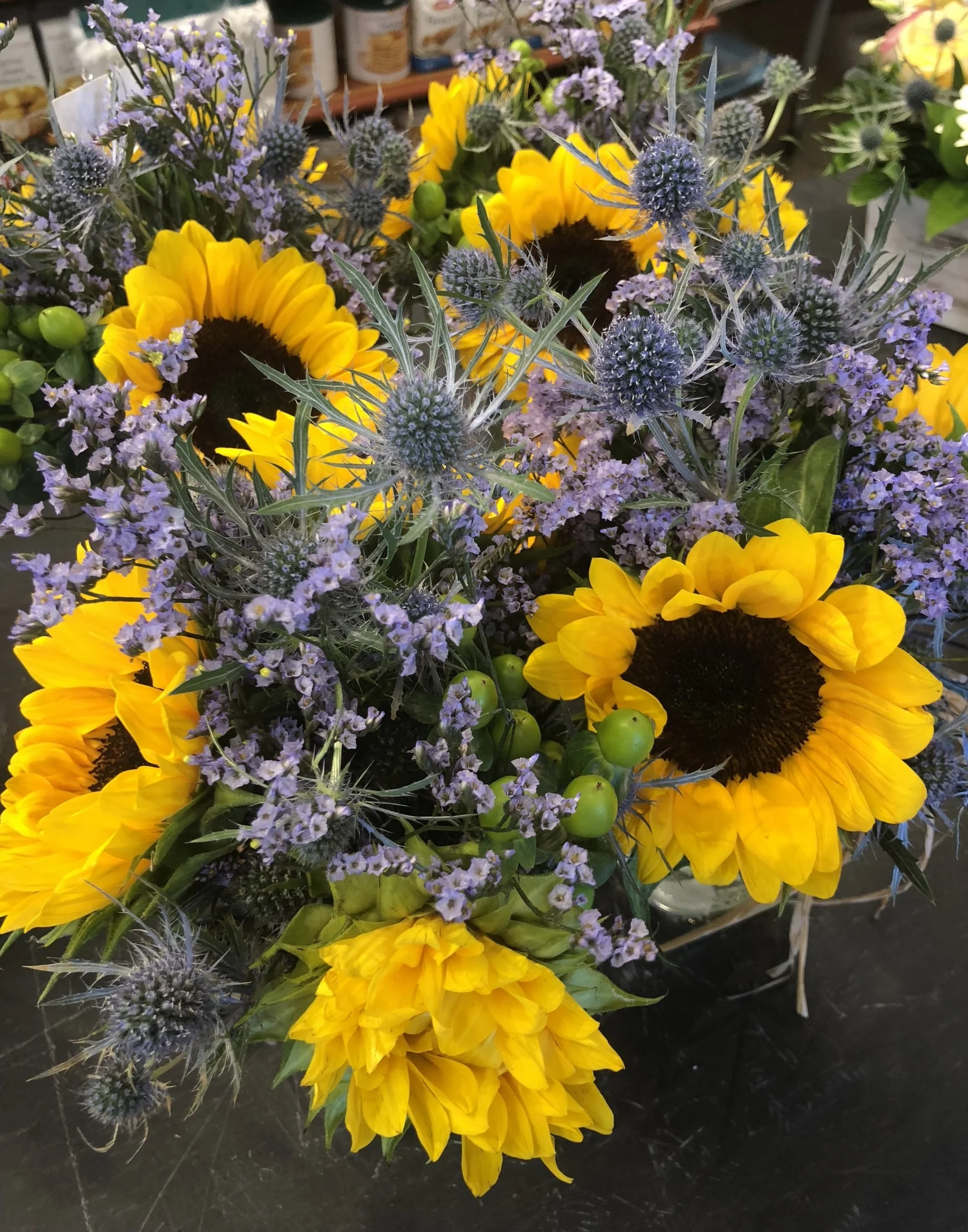 Russo's hand made floral arrangements of Sunflowers, Eryngium, Limonium and Green Hypericum berries 