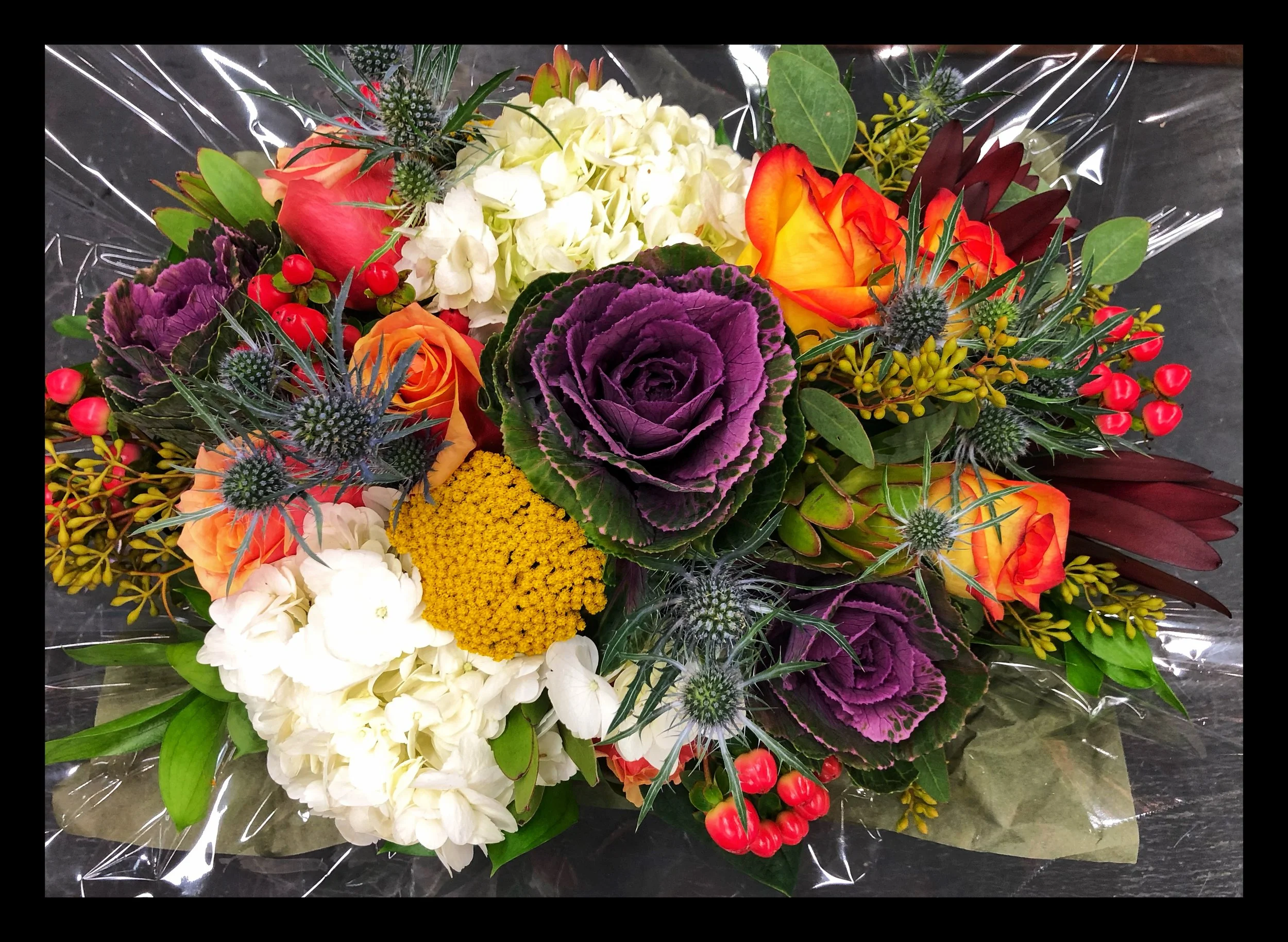 Floral arrangements with roses, hydrangeas, hypericum berries and kale at Russo’s!
