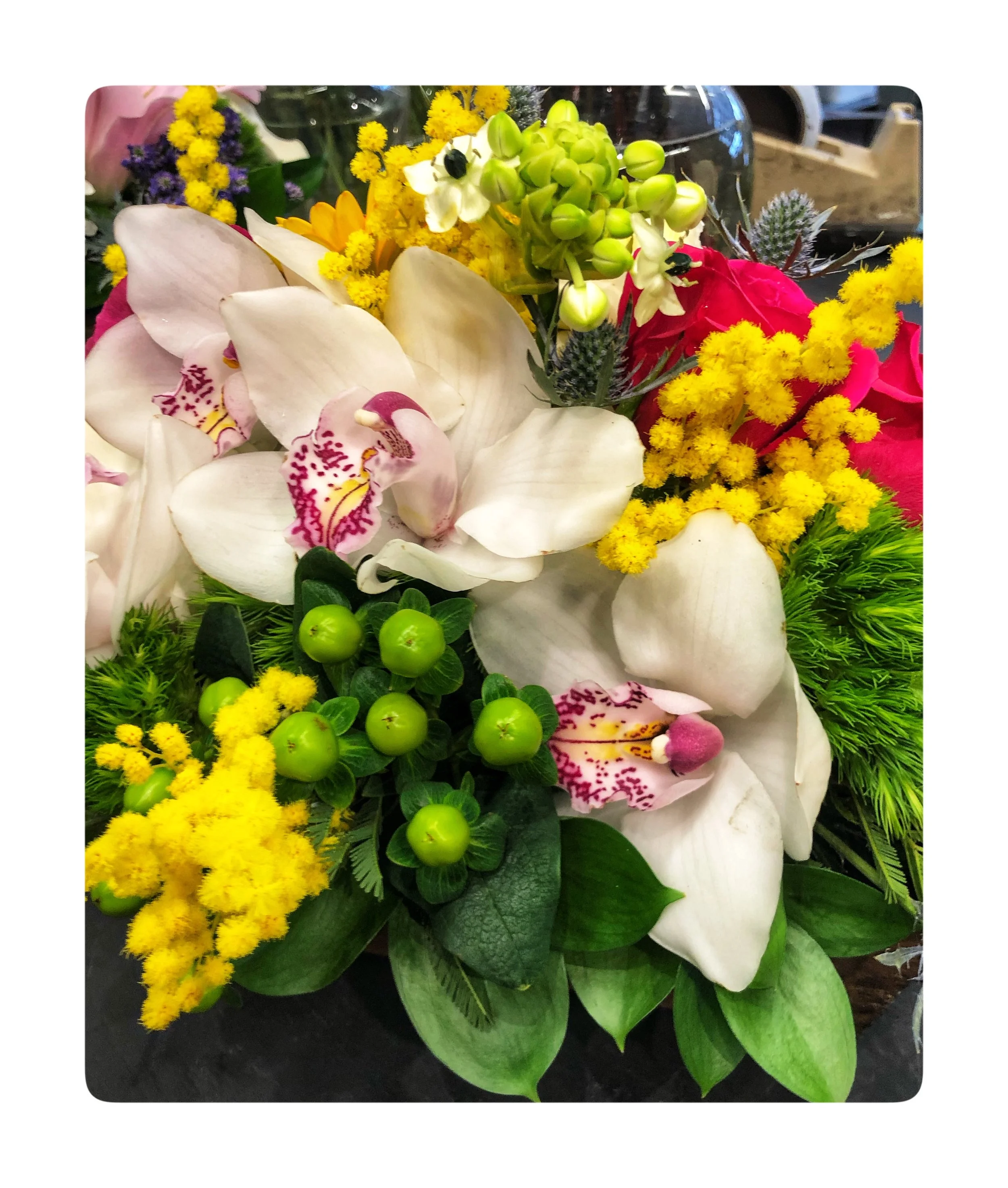 Orchid bouquet with Mimosa Flowers which are the symbol for International Women’s Day on March 8.