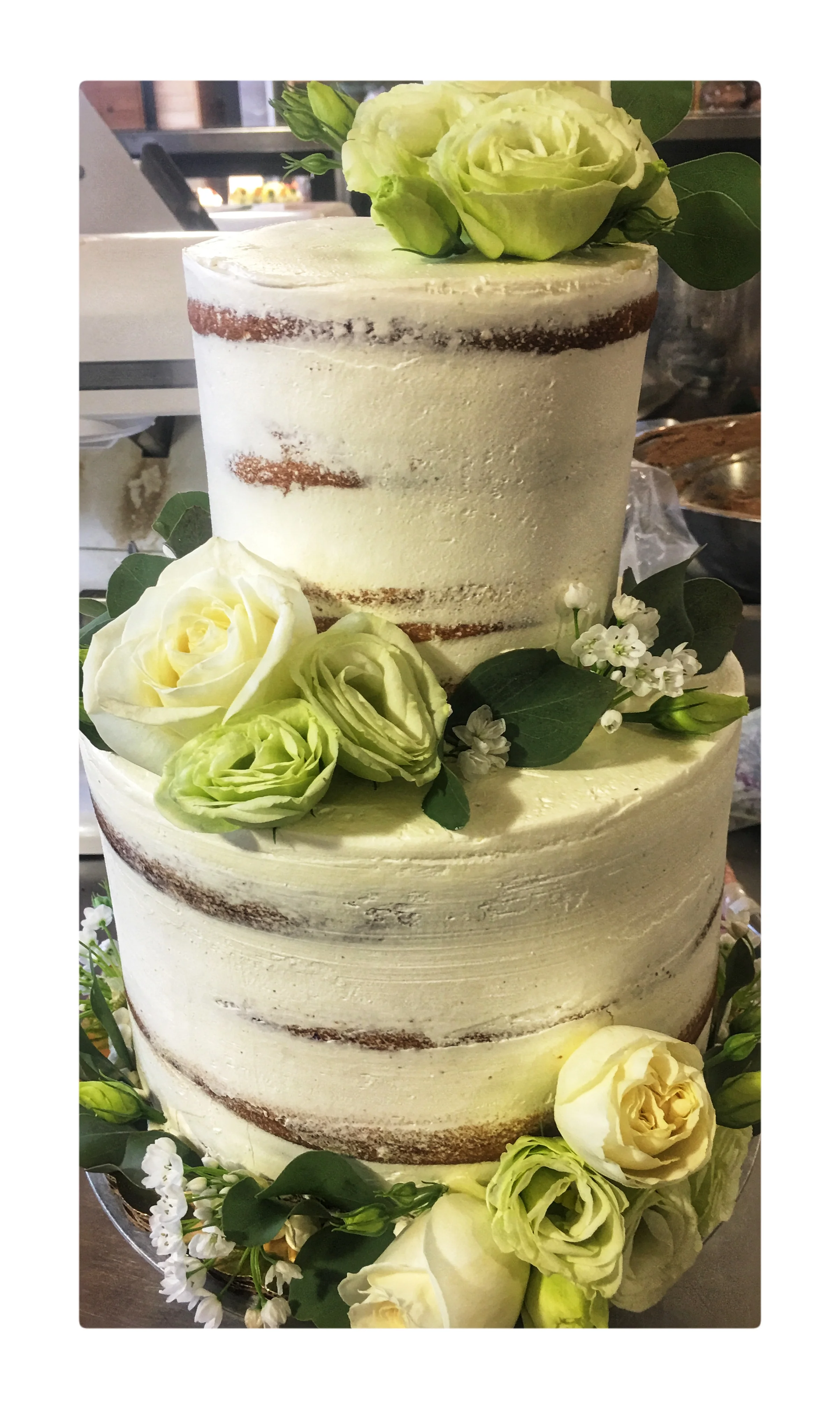 Cake decorated with fresh flowers and distressed frosting.