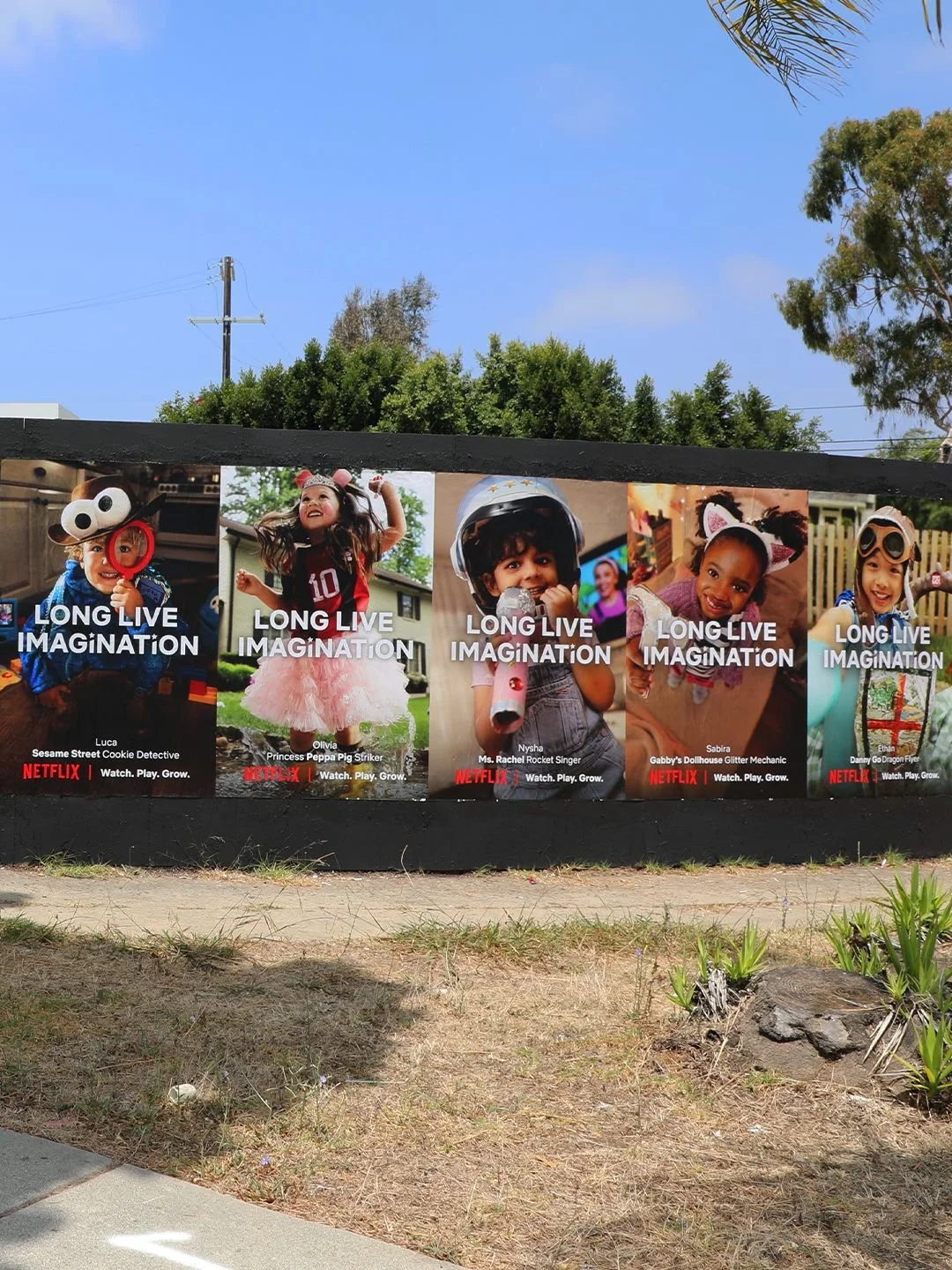 Poster featuring five children in costumes promoting a Netflix series called 'Long Live Imagination' with each child's name, image, and costume, set outdoors with trees and a blue sky in the background.