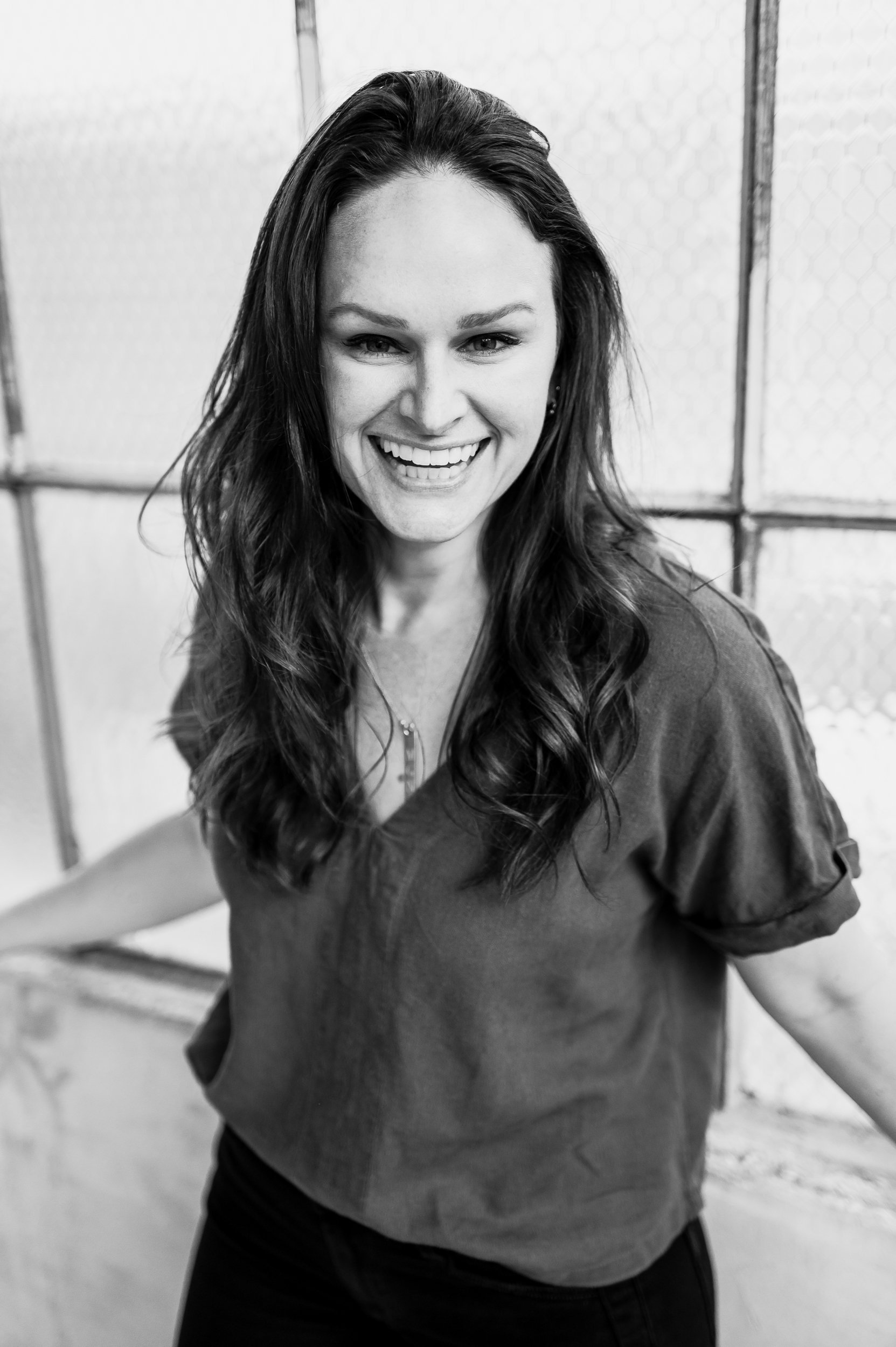 A young woman smiling at the camera, image is in black and white