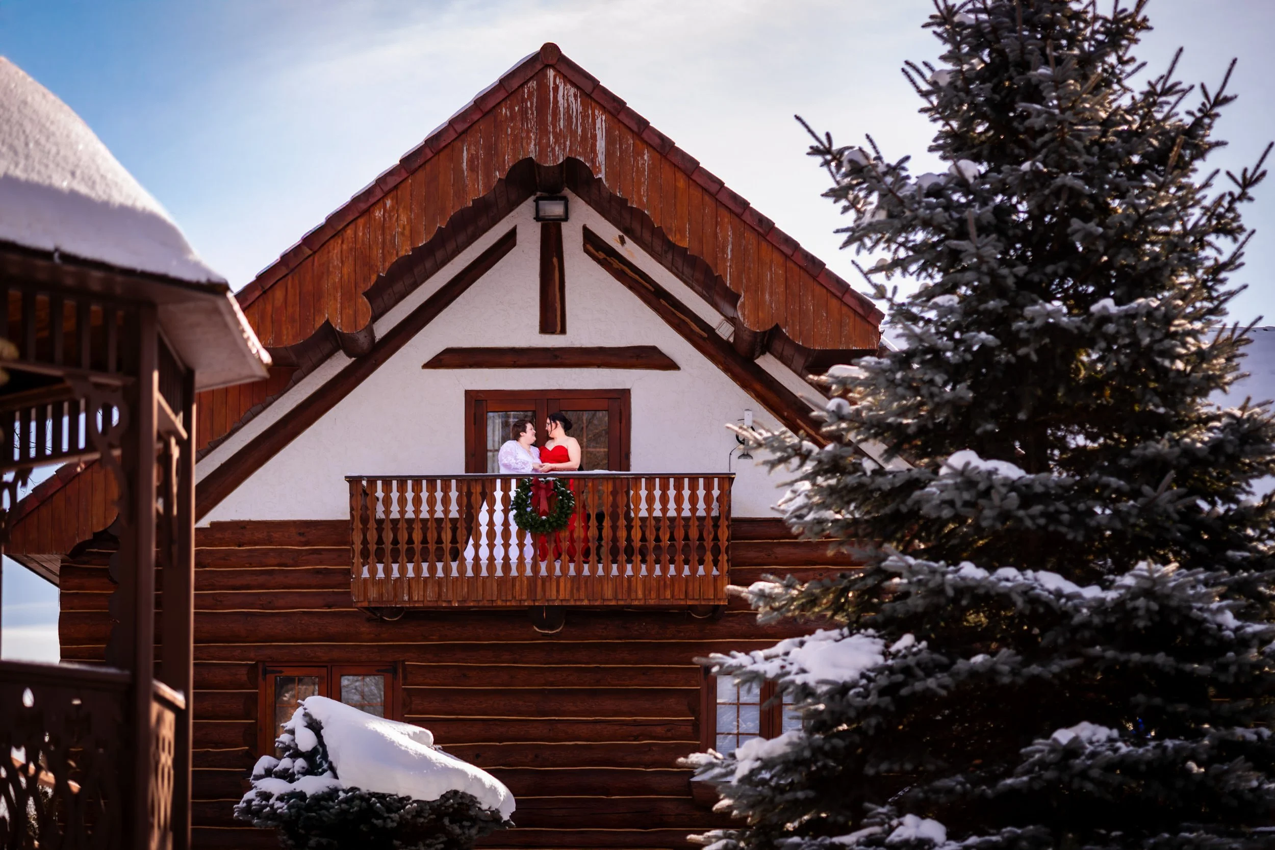 queer winter wedding cambridge ontario two brides on balcony snowy lodge christmas wedding portrait