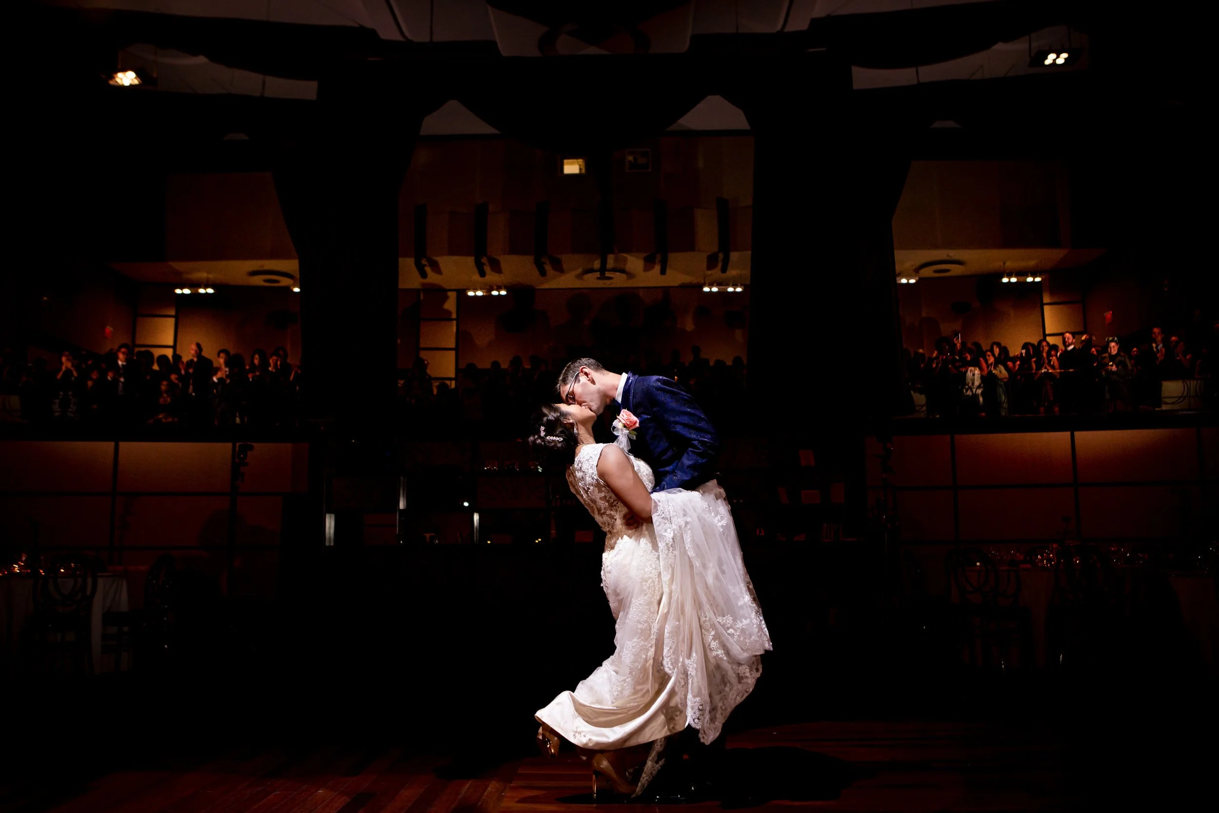 Bride and groom sharing their first dance at The Eglinton Grand with guests watching from the balcony