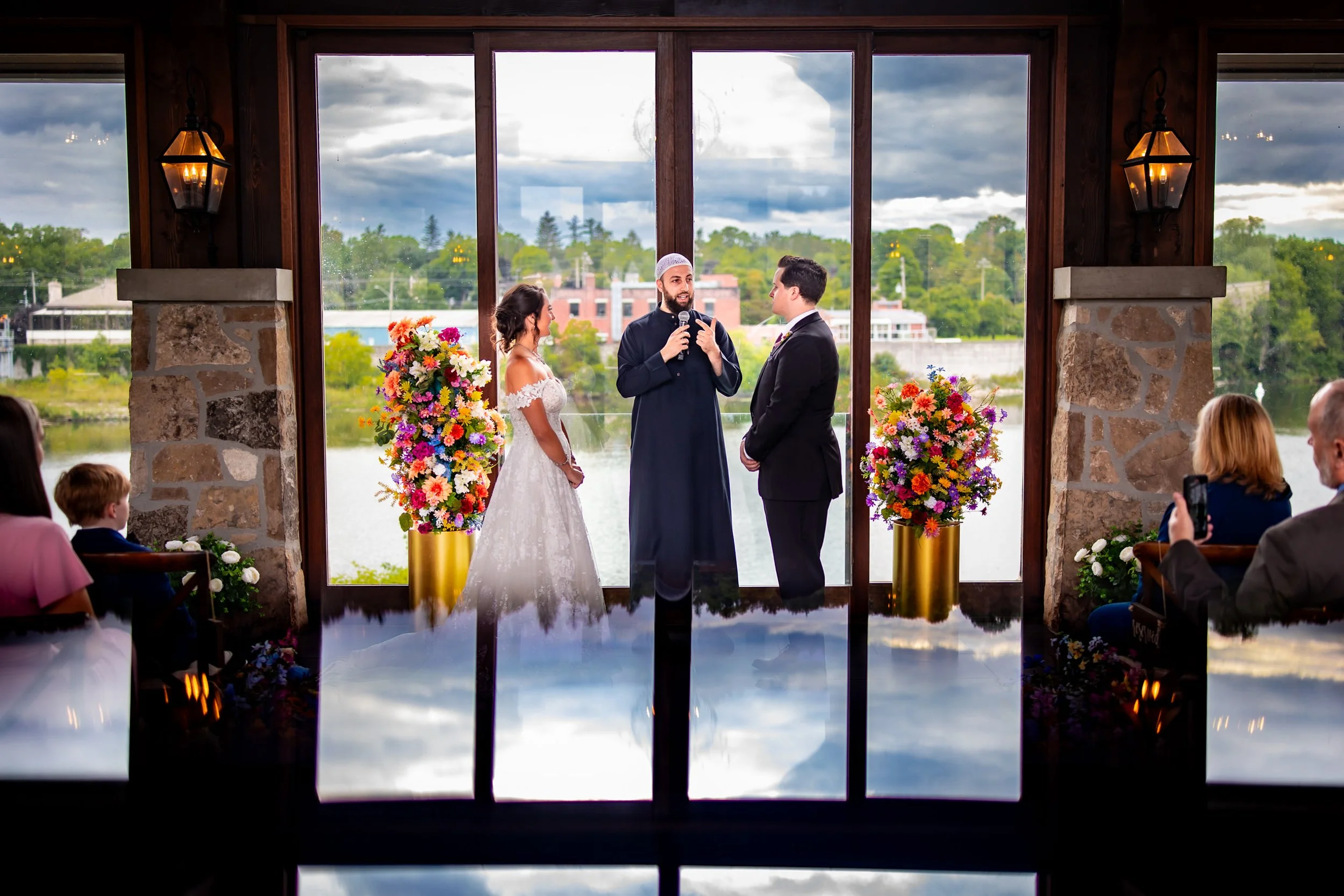 Casa Loma wedding ceremony in Toronto with couple exchanging vows inside the conservatory, captured with creative reflection and candid wedding photography style