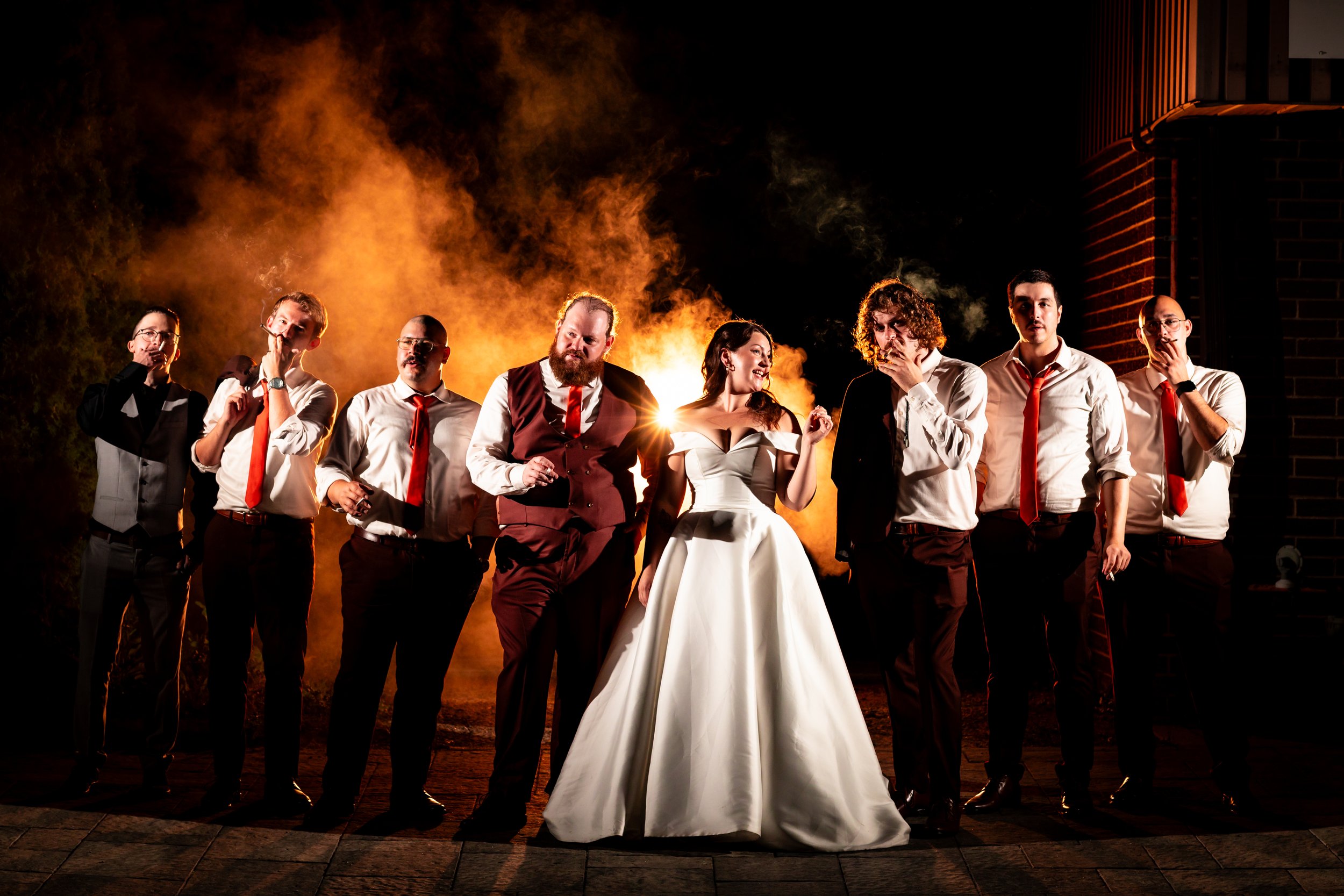 Vanessa and Justin with their wedding party in a dramatic nighttime portrait in Harrow.