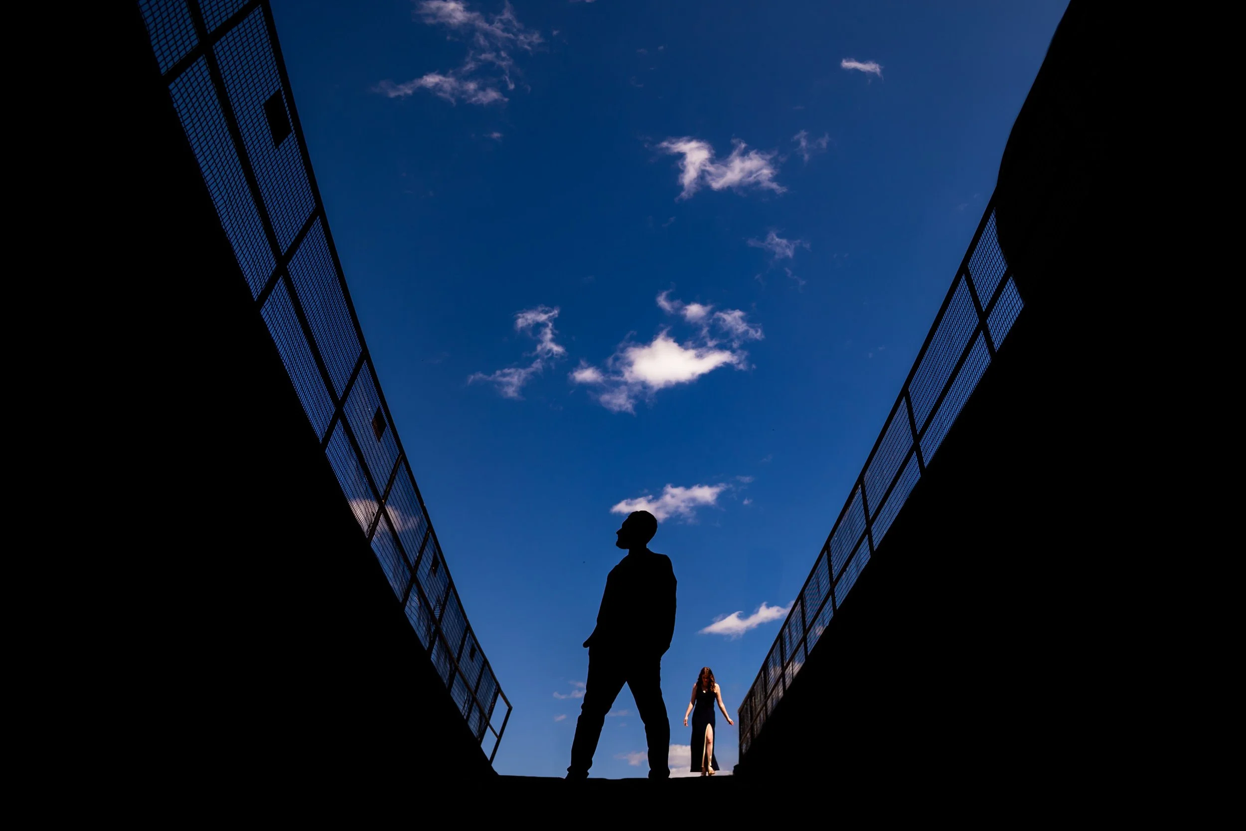 Toronto engagement photographer capturing a creative silhouette of a couple under a blue sky, candid and cinematic pre wedding photo