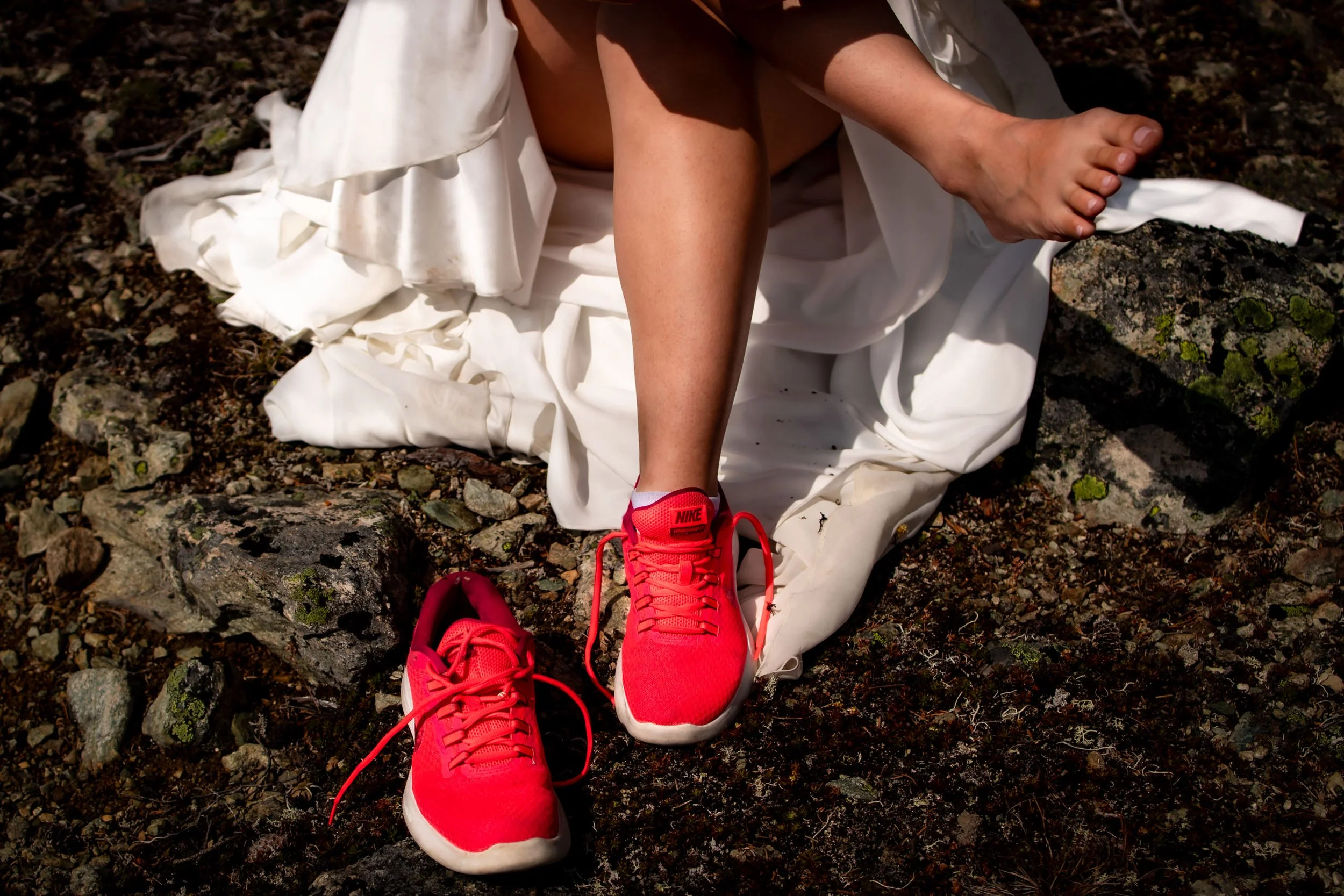 Bride wearing red sneakers instead of traditional wedding shoes during outdoor wedding, unique and comfortable bridal footwear