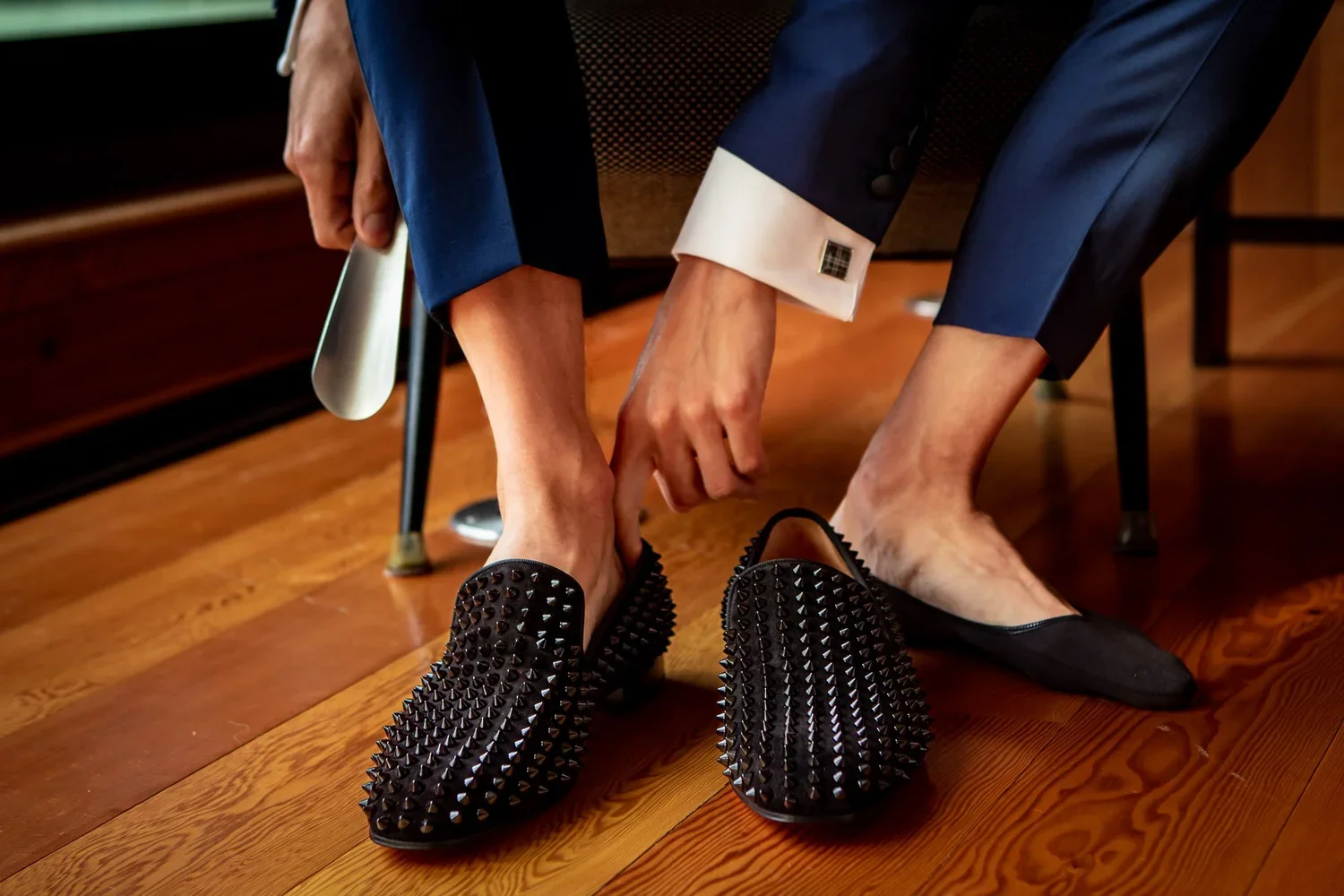 Groom putting on black wedding shoes during getting ready, stylish groom footwear for wedding day