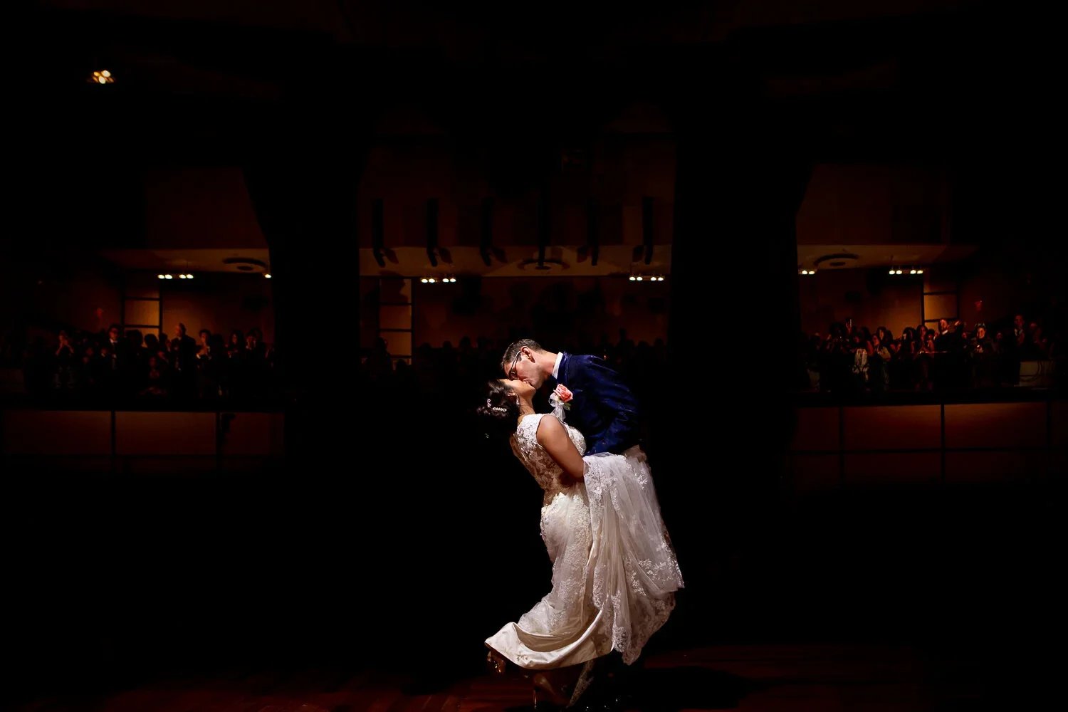 Eglinton Grand wedding first dance photo with the couple kissing under dramatic theatre lighting in Toronto