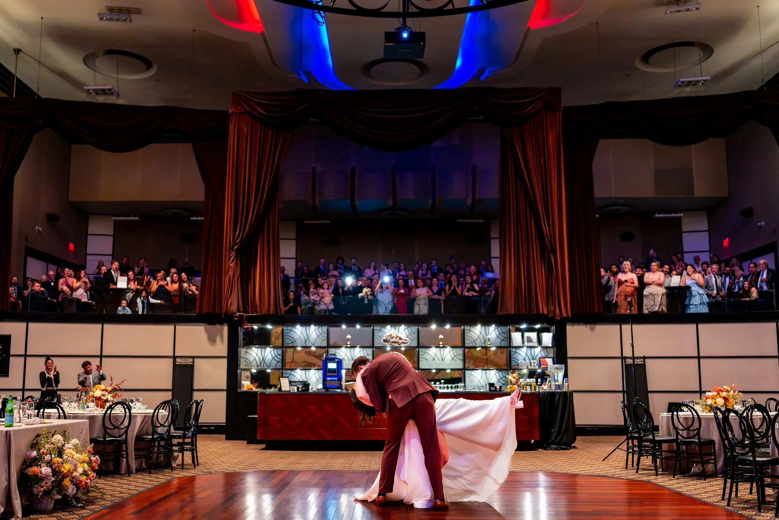 eglinton grand wedding first dance in toronto with dramatic lighting and guests watching from balcony during reception