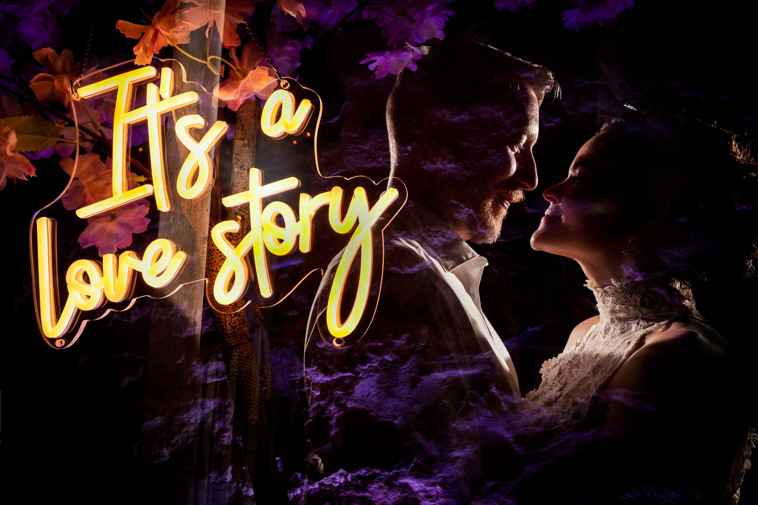 Creative nighttime portrait of Cecilia and Darren beside an “It’s a love story” neon sign at The Millcroft Inn in Alton, Ontario.