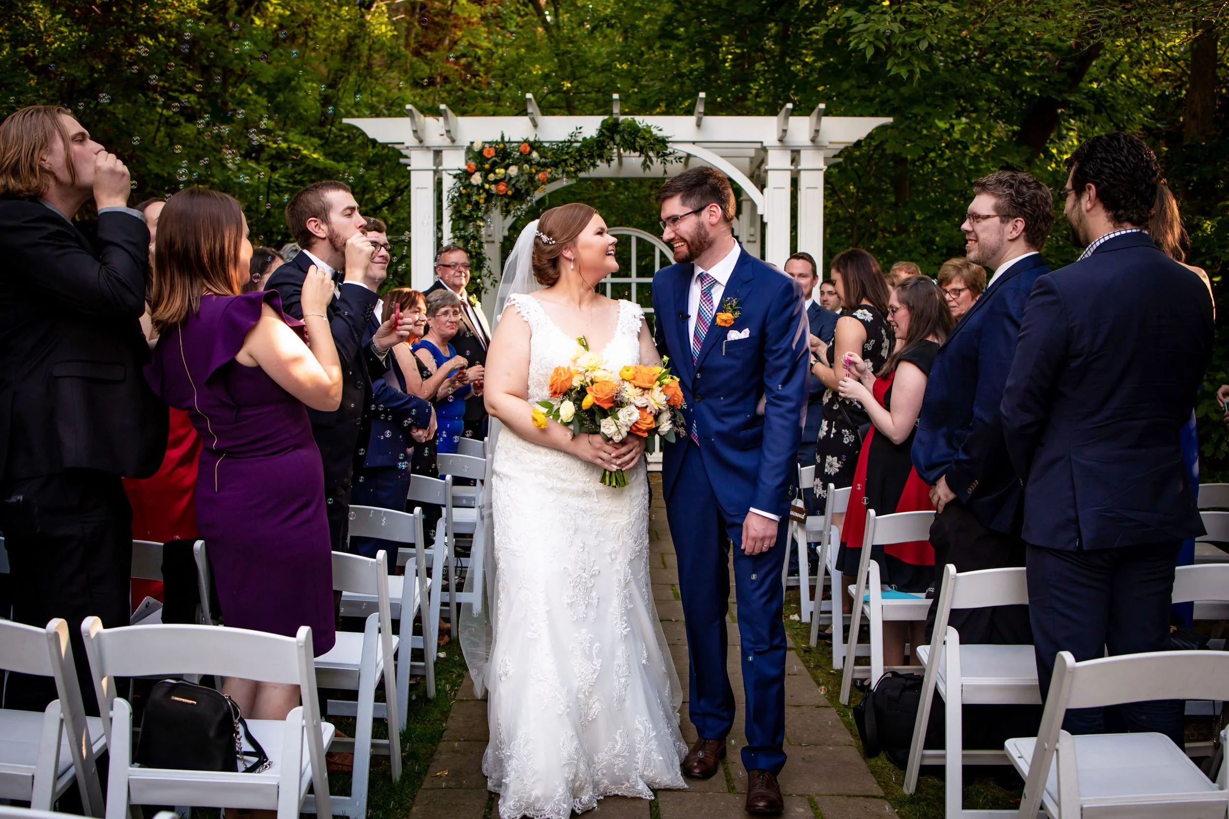 Bride and groom walking back down the aisle after their outdoor wedding ceremony at Ancaster Mill