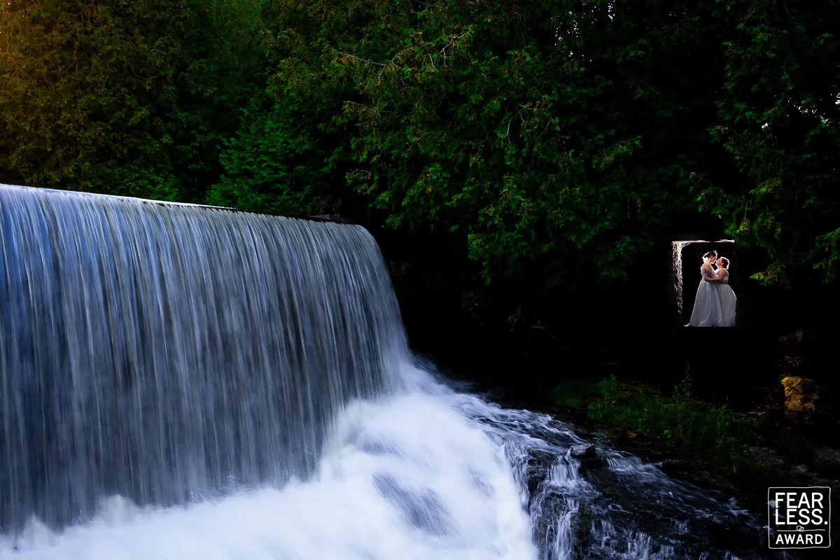 fearless award winning wedding photo couple by waterfall creative composition candid moment