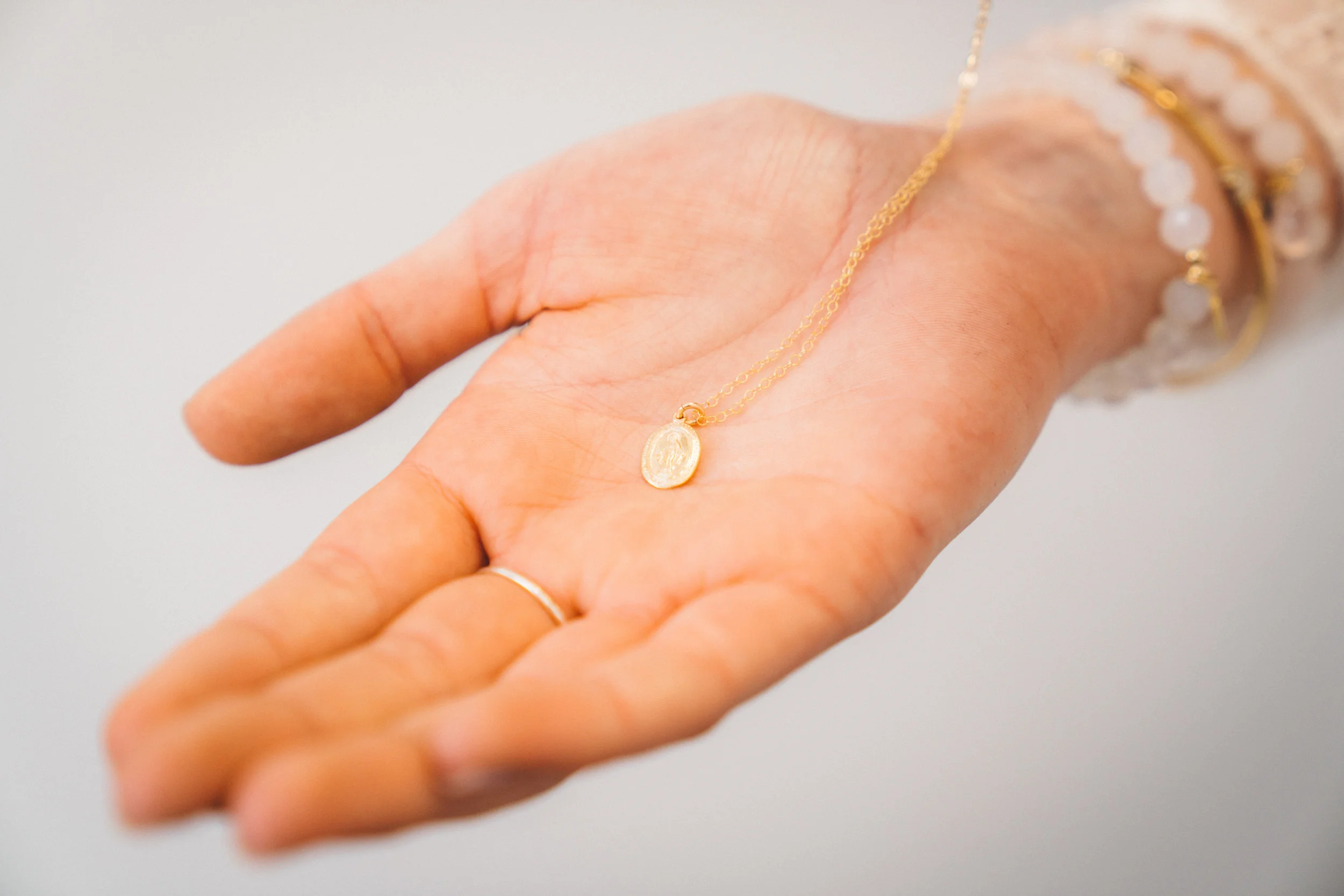 Simple gold plated Mother Medallion symbolizing unconditional love