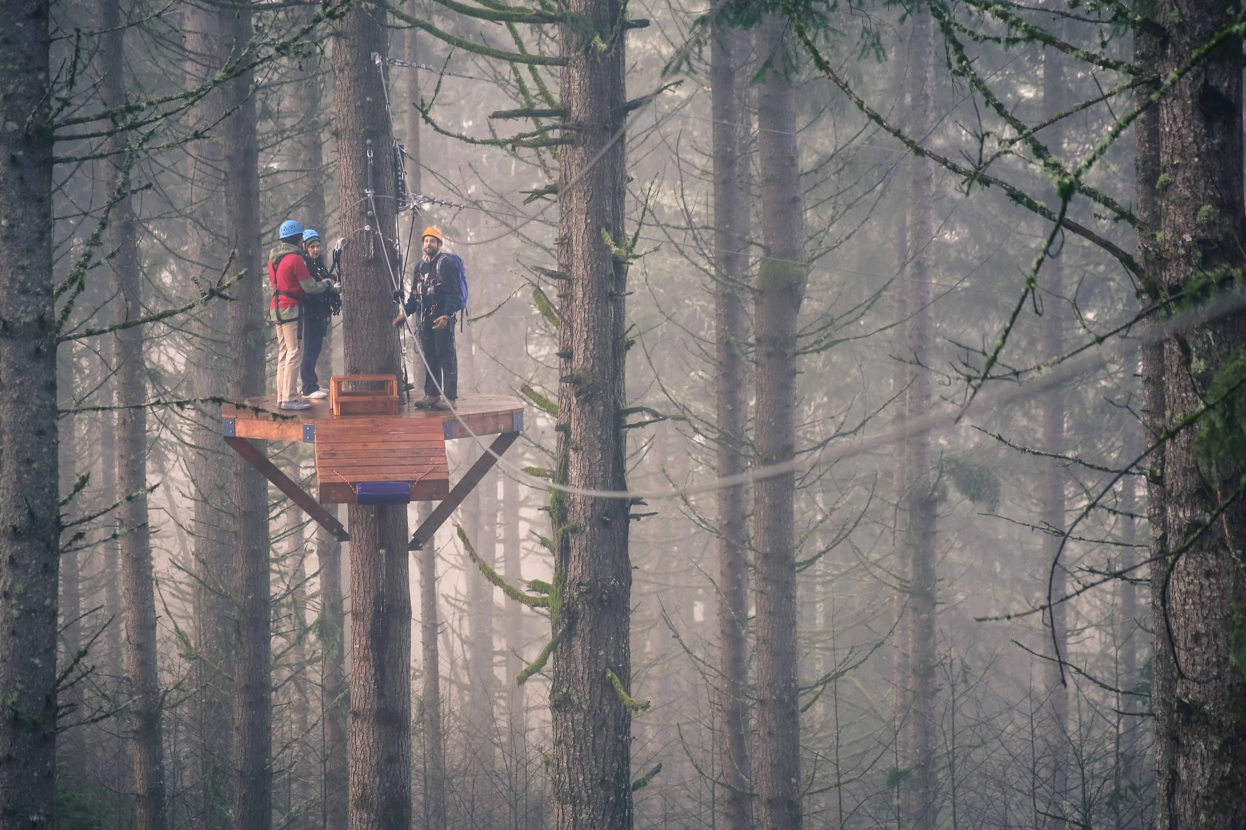 Zipline platform with standing people communicating on course